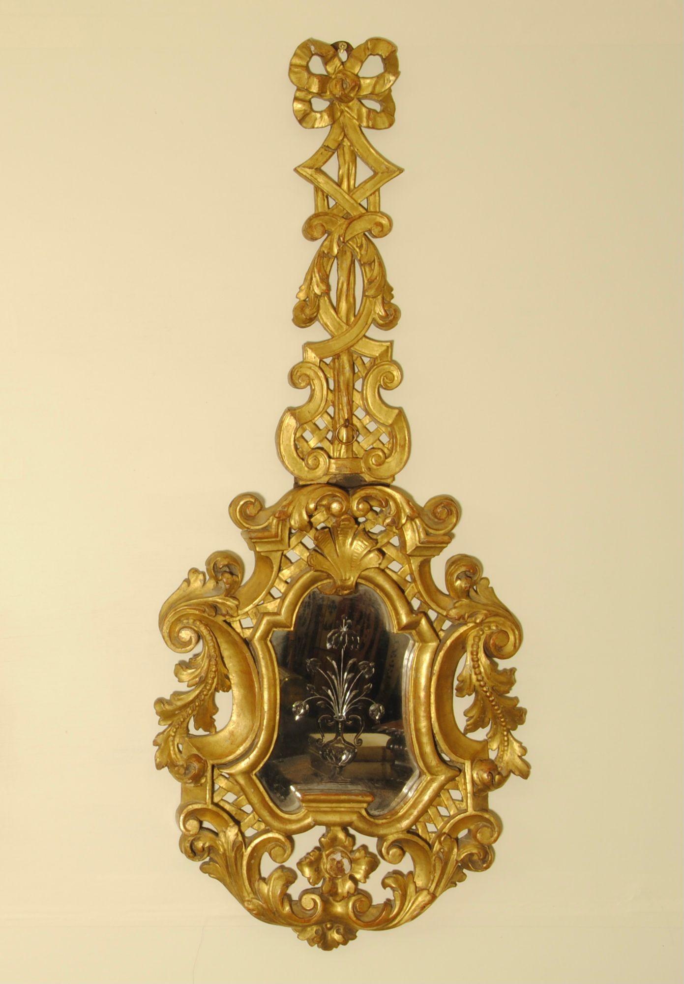 Un'affascinante coppia di specchi in legno dorato intagliato dell'inizio del XIX secolo, i cui piatti sono incisi con un cesto di fiori appoggiato sul legno intagliato. Fiorentino, 1830 circa