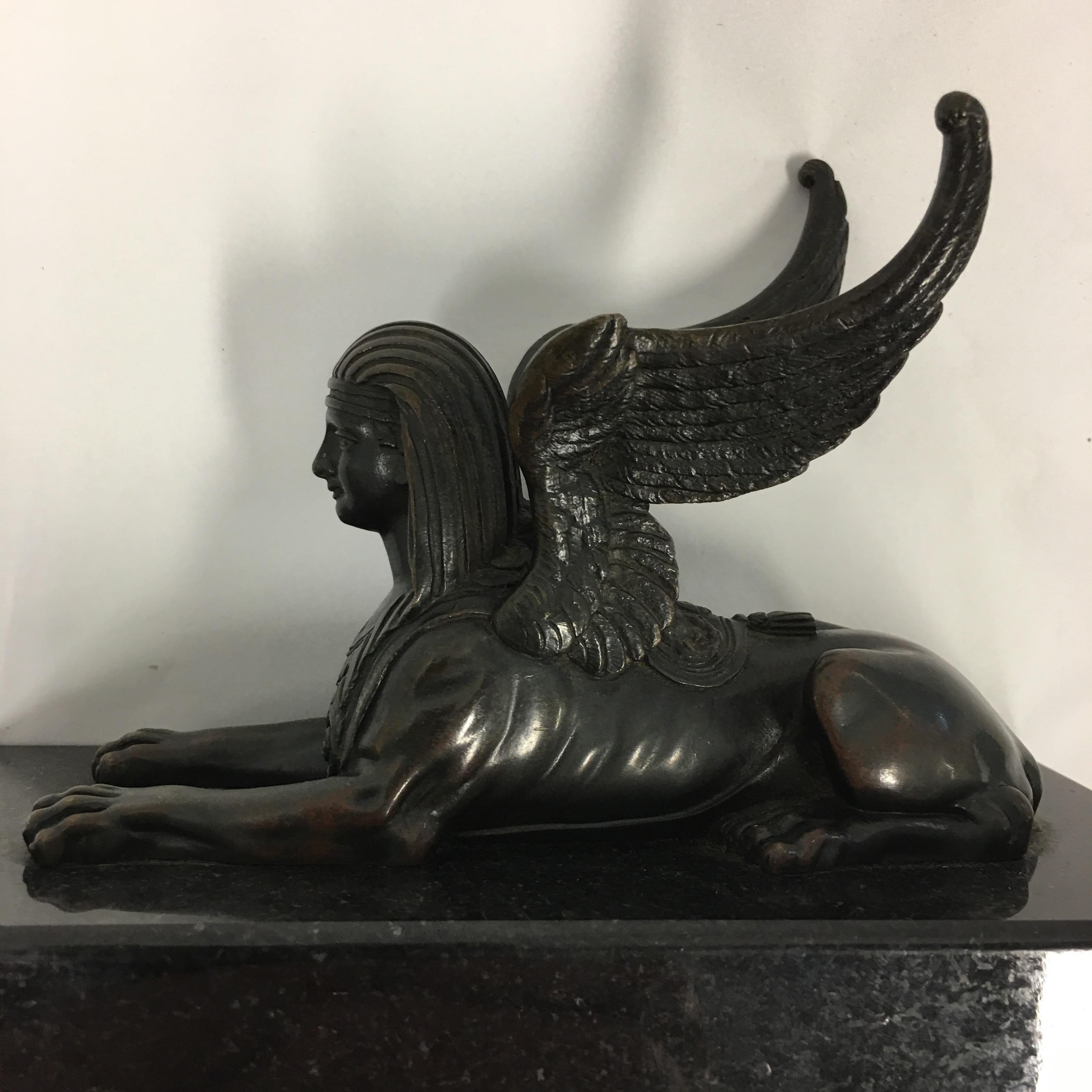 A rear pair 0f 19th. century Italian Grand Tour sculptures of winged patinated bronze Sphinxes above a black marble base. These sculptures were purchased by rich aristocratic children on there travels to European Cities as souvenirs to show how well