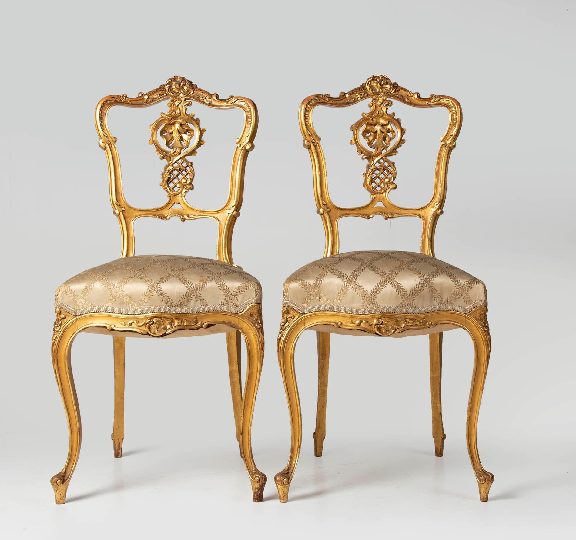 Two beautiful French side table. The chairs have refined Louis XV style carvings. The seats are gilded with gold leaf. The seats are covered with silk. The upholstery is somewhat worn, but not broken. These chairs have a beautiful old patina and