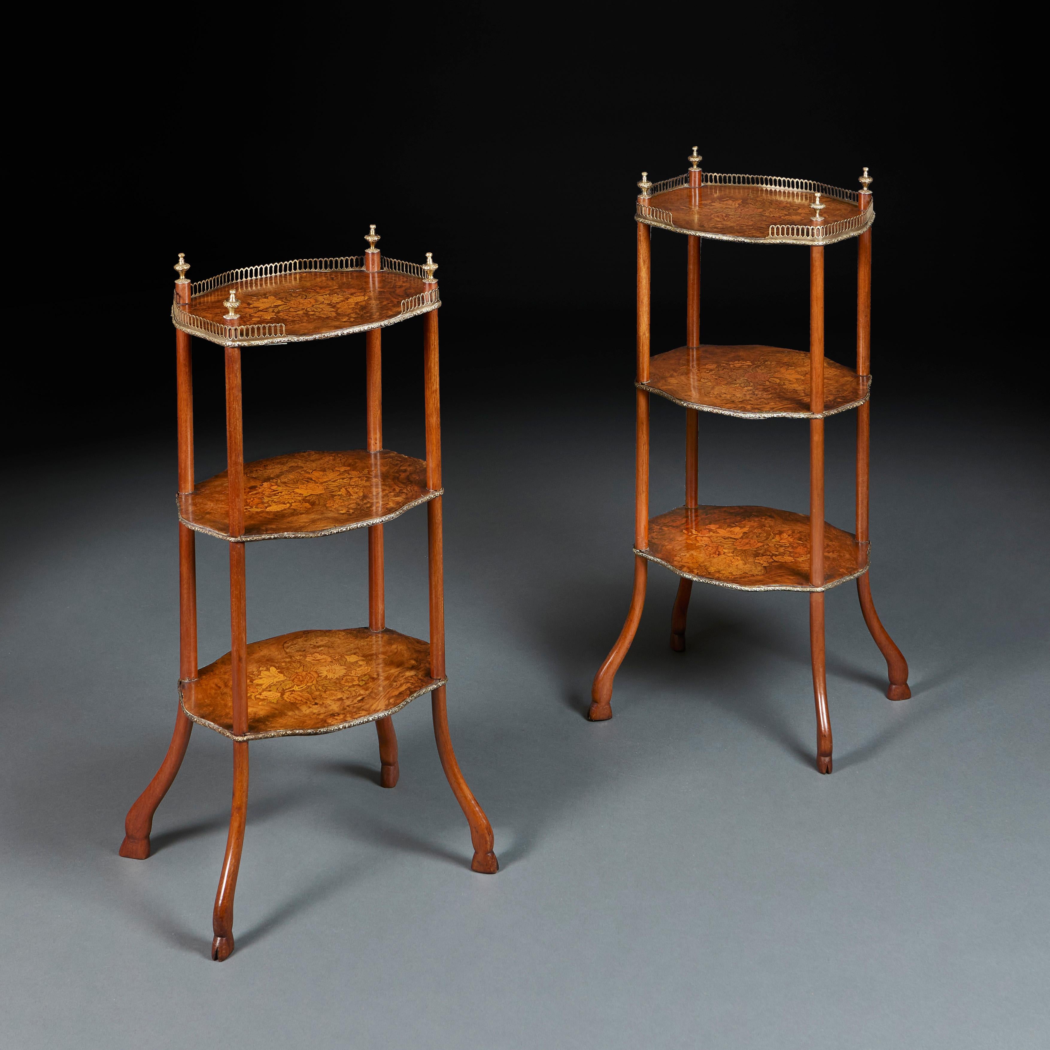 England, circa 1850

A fine pair of mid nineteenth century three tier etageres with marquetry tops showing sprays of flowers, with brass galleries, the uprights surmounted by brass acorn finials, and terminating in splayed legs and hoof
