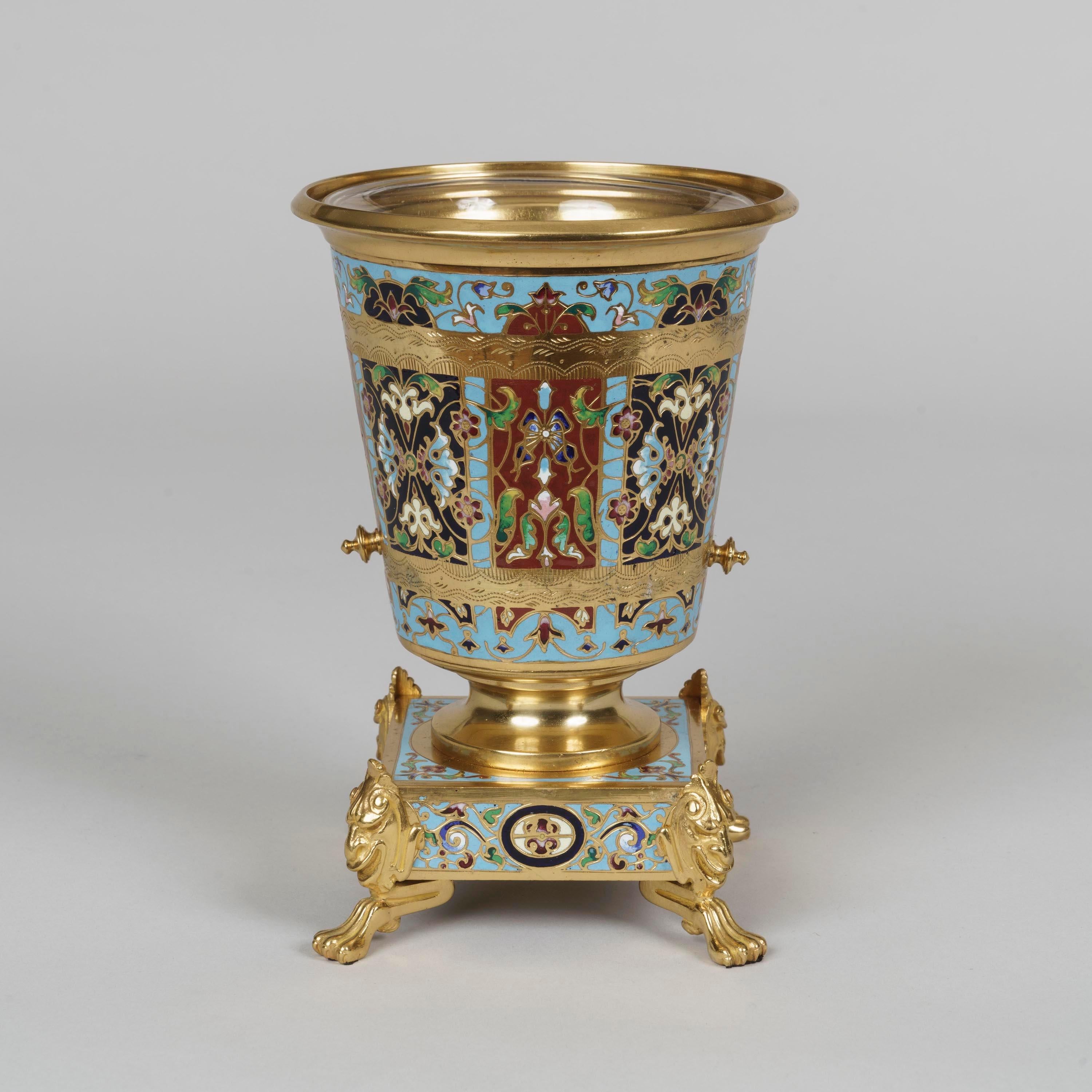 A pair of gilt bronze and champlevé enamel vases

Constructed from solid fire-gilded bronze, the miniature decorative vases supported on square plinths rising from paw feet, the conical bodies having several registers of engraved ornament