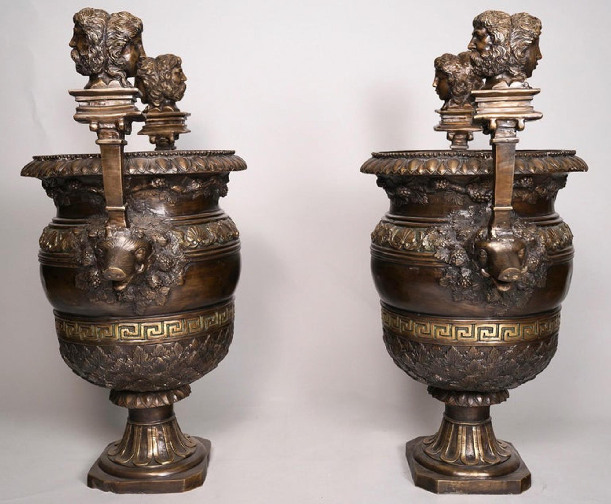 Ein Paar pompejanische Urnen aus patinierter Bronze im klassizistischen Stil von CIRCA 1850. Diese schönen Urnen haben Griffe aus Wildschweinköpfen, die von doppelseitigen klassischen männlichen und weiblichen Maskenbüsten überragt werden, die mit