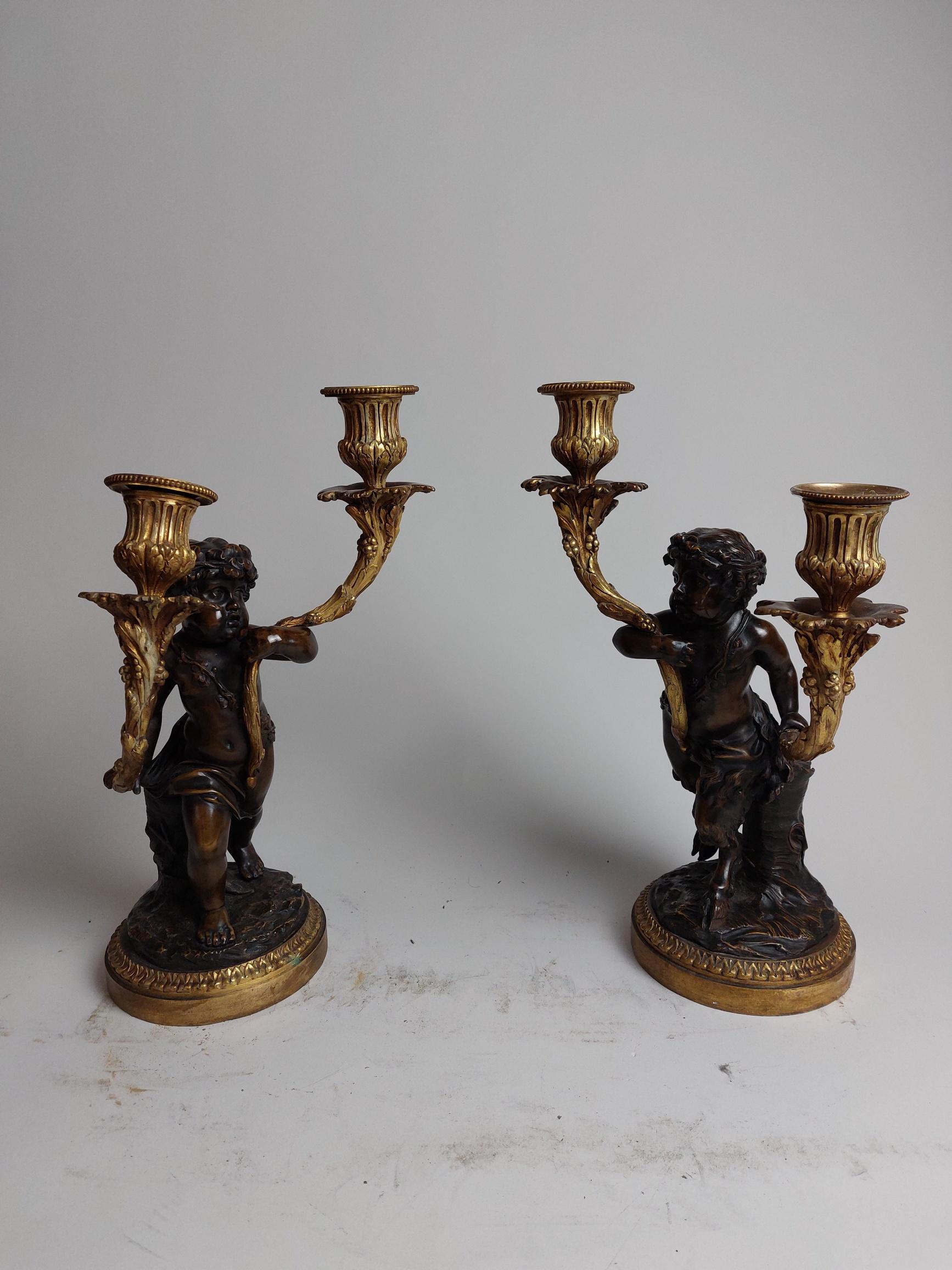 A pair of naturalistic 19th century ormolu candlestick holders held by bronze fawns.