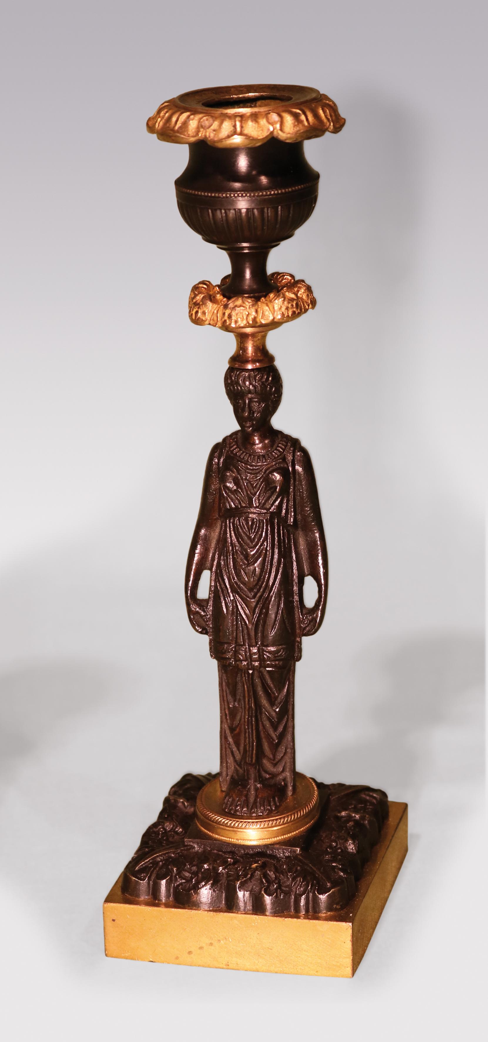 Une paire de chandeliers en bronze et bronze ciselé du début du 19e siècle de la période Régence, avec des becs cannelés et guillochés en forme d'urne au-dessus de tiges de femmes classiques montées sur des plates-formes circulaires guillochées se