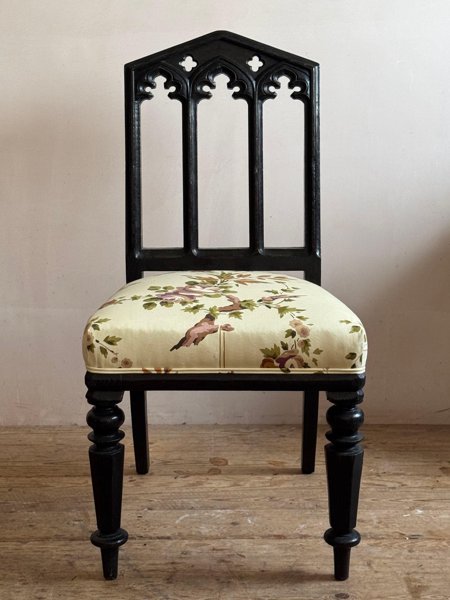A pair of mid 19thC ebonised oak gothic revival chairs with upholstered seats. 95cm high x 49cm wide x 53cm deep.