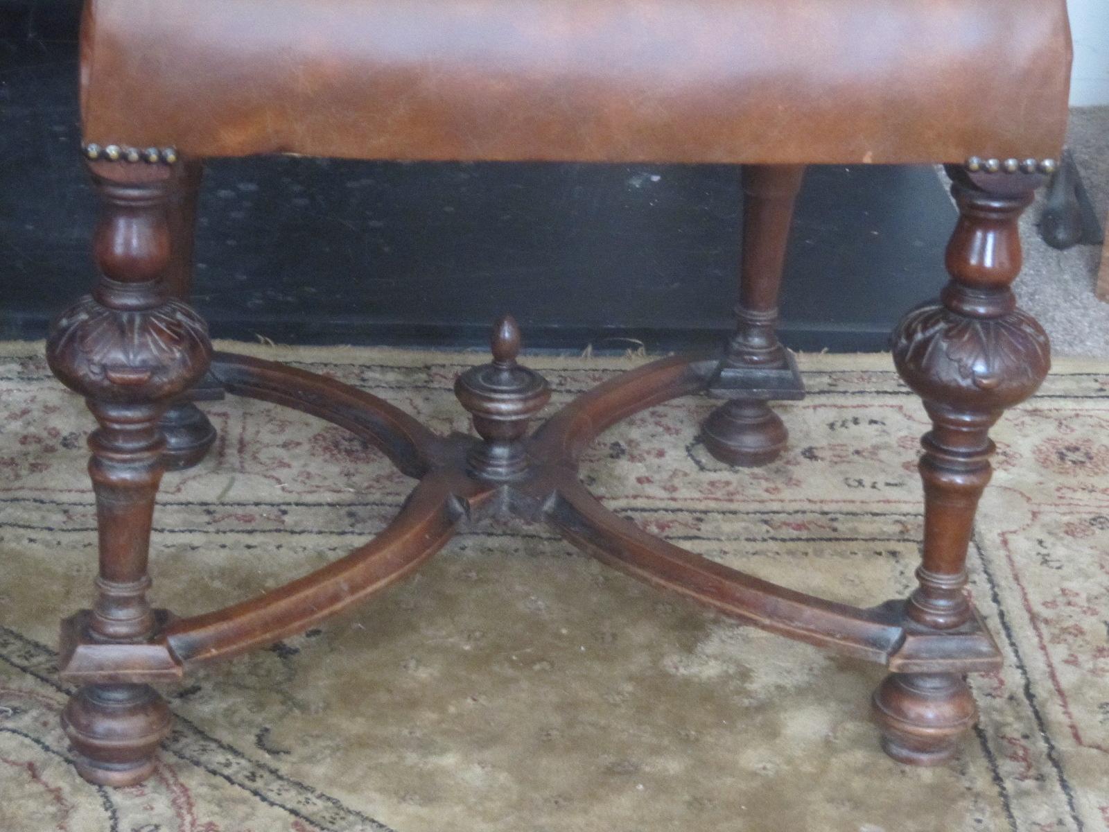 A pair of 19thC profusely carved mahogany framed side chairs with foliate scrolled ornament, newly upholstered in sunning Italian distressed leather, finished with studs. the high backs between baluster and block uprights, raised on carved cup and