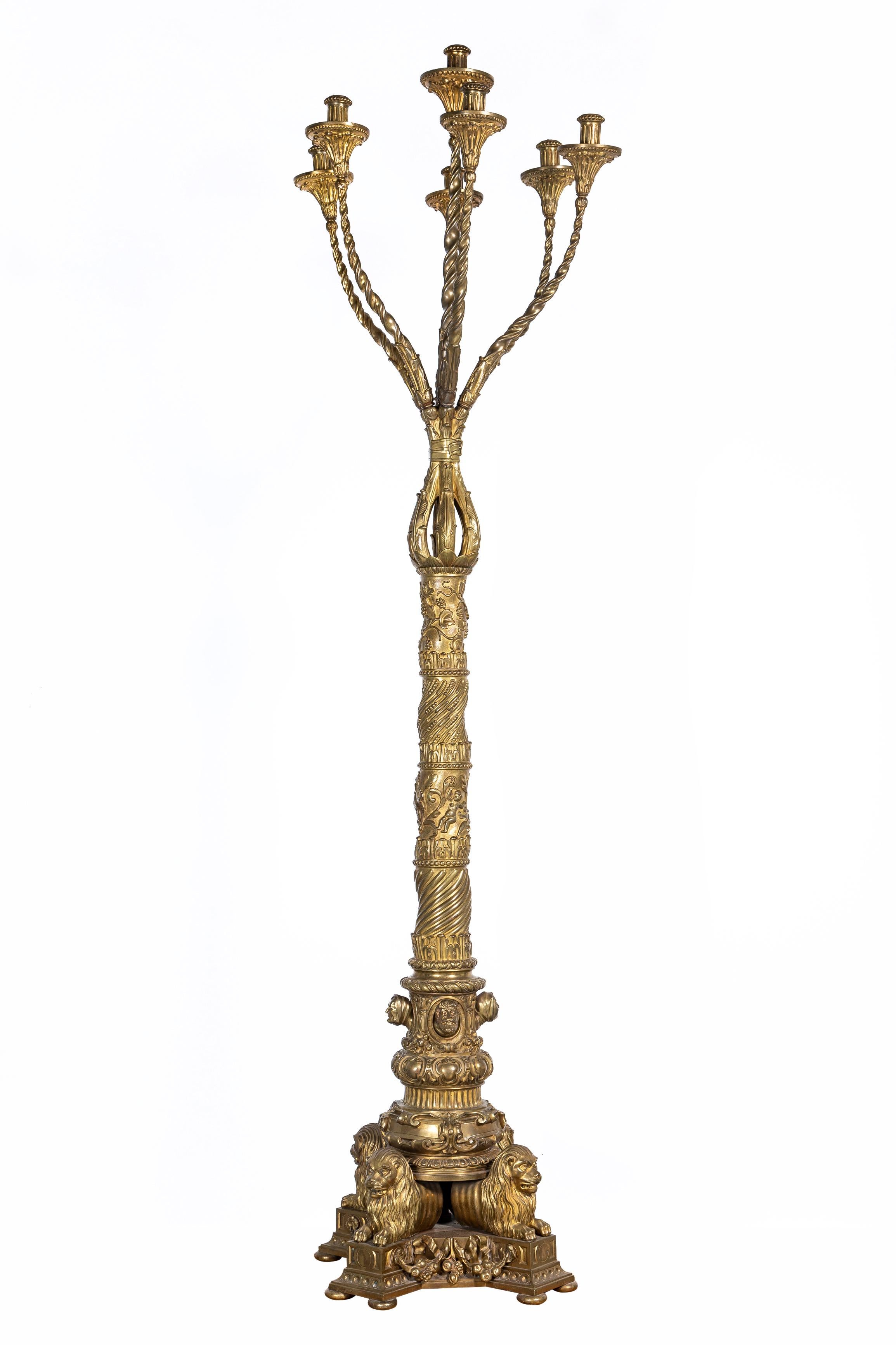 Una grande e rara coppia di esemplari del 20° secolo. Torciere a 7 bracci in bronzo dorato Caldwell Century American con piedi di leone. Ciascuna di esse ha un fusto a forma di salomone modellato con scanalature a spirale e foglie e grappoli d'uva
