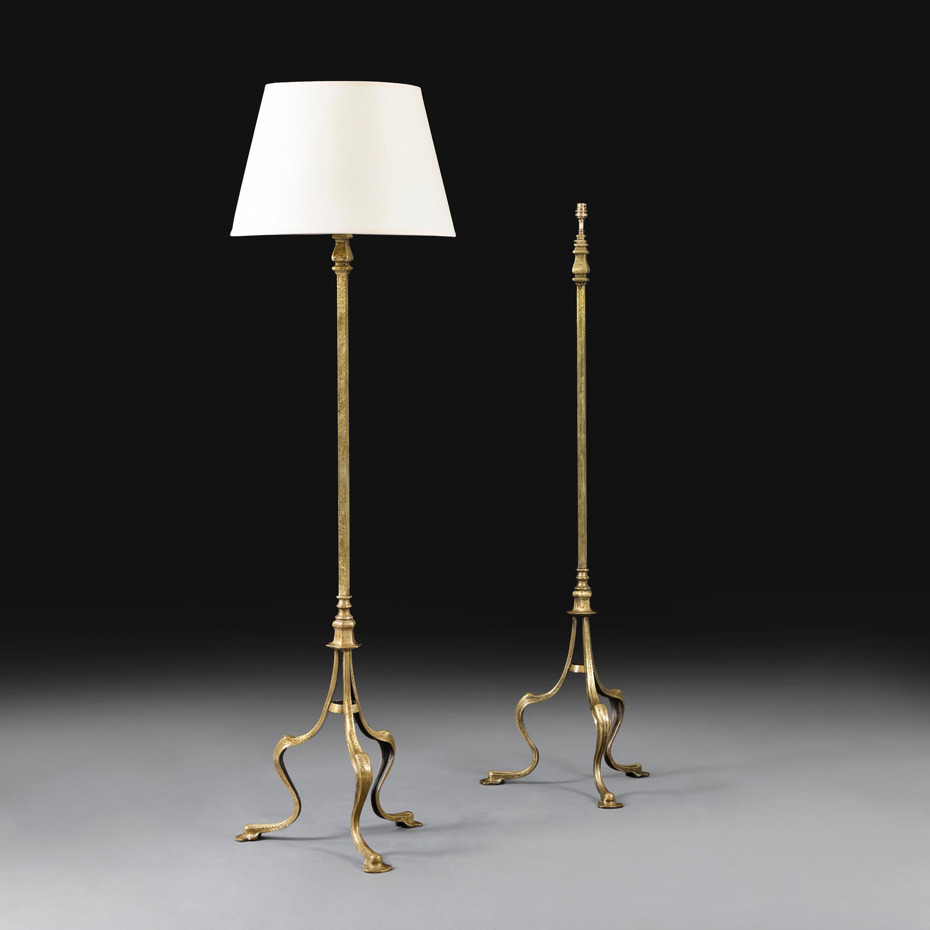 Inghilterra, circa 1910.

Coppia di lampade standard in ottone martellato dell'inizio del XX secolo, con stelo quadrato sostenuto da gambe a treppiede ricurve e piedi a pad.

Altezza dello stelo 138,00 centimetri.
Altezza con paralume 170,00