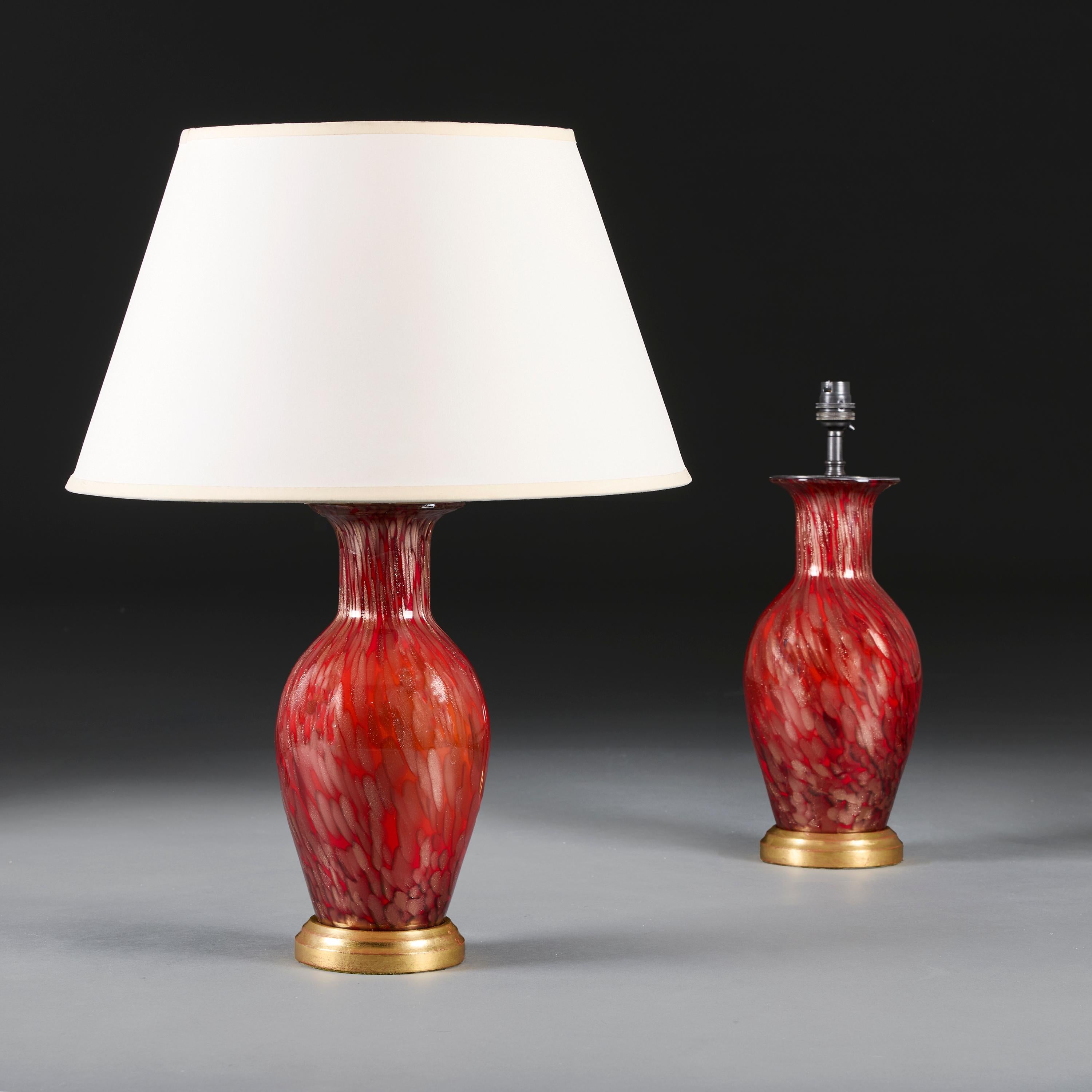 Italy, circa 1950

A pair of red tortoiseshell Murano glass baluster vases with aventurine inclusions throughout, now converted into lamps and mounted on giltwood bases.

Height of vase   31.00cm

Width of body   14.00cm

Please note:

Lampshade not