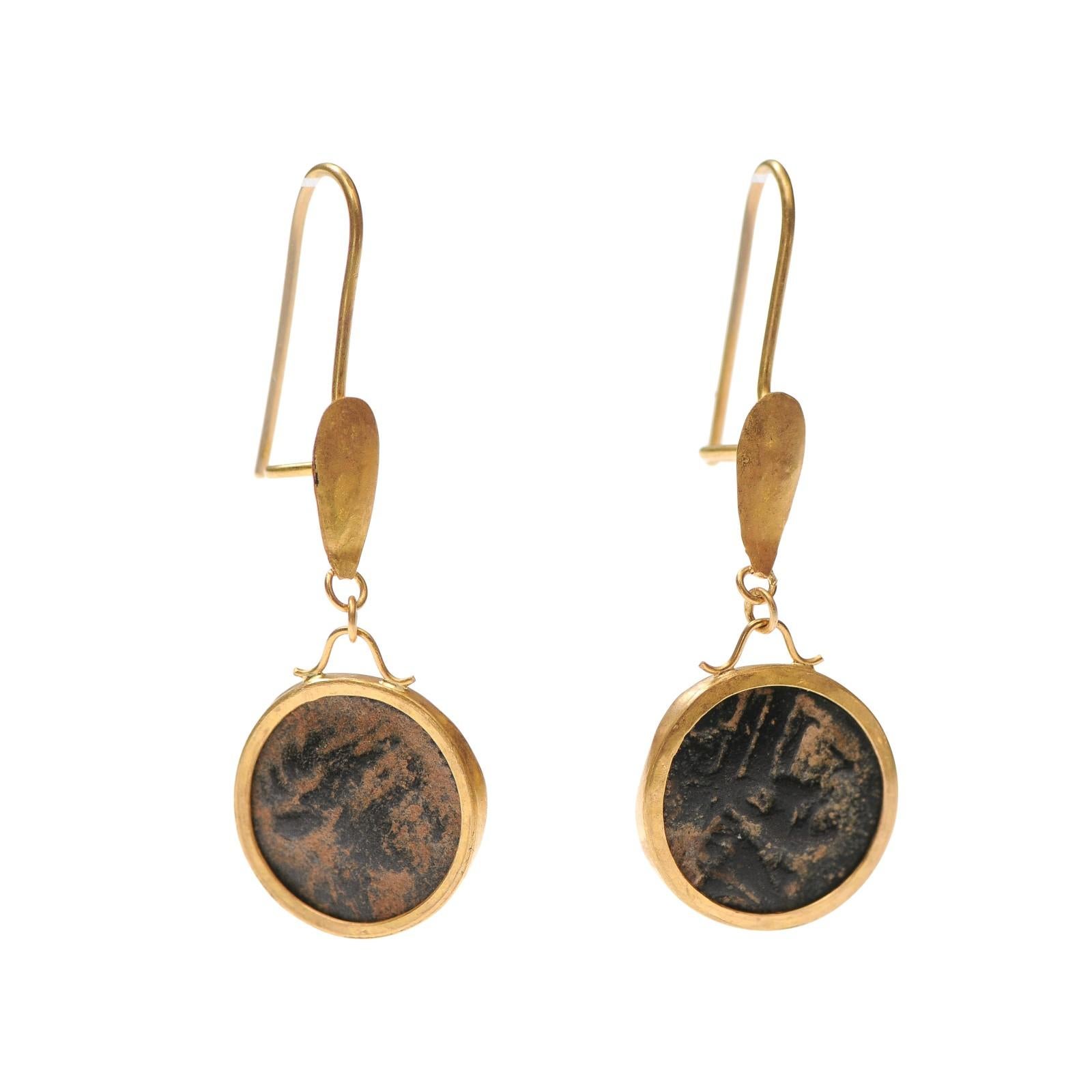 Un paio di splendidi orecchini realizzati con piccole monete romane in bronzo e oro a 21 carati. Questo paio di orecchini pendenti in oro e bronzo sono delicati ma di grande effetto, con un'altezza di quasi 2 pollici. Sembrano di ispirazione etrusca