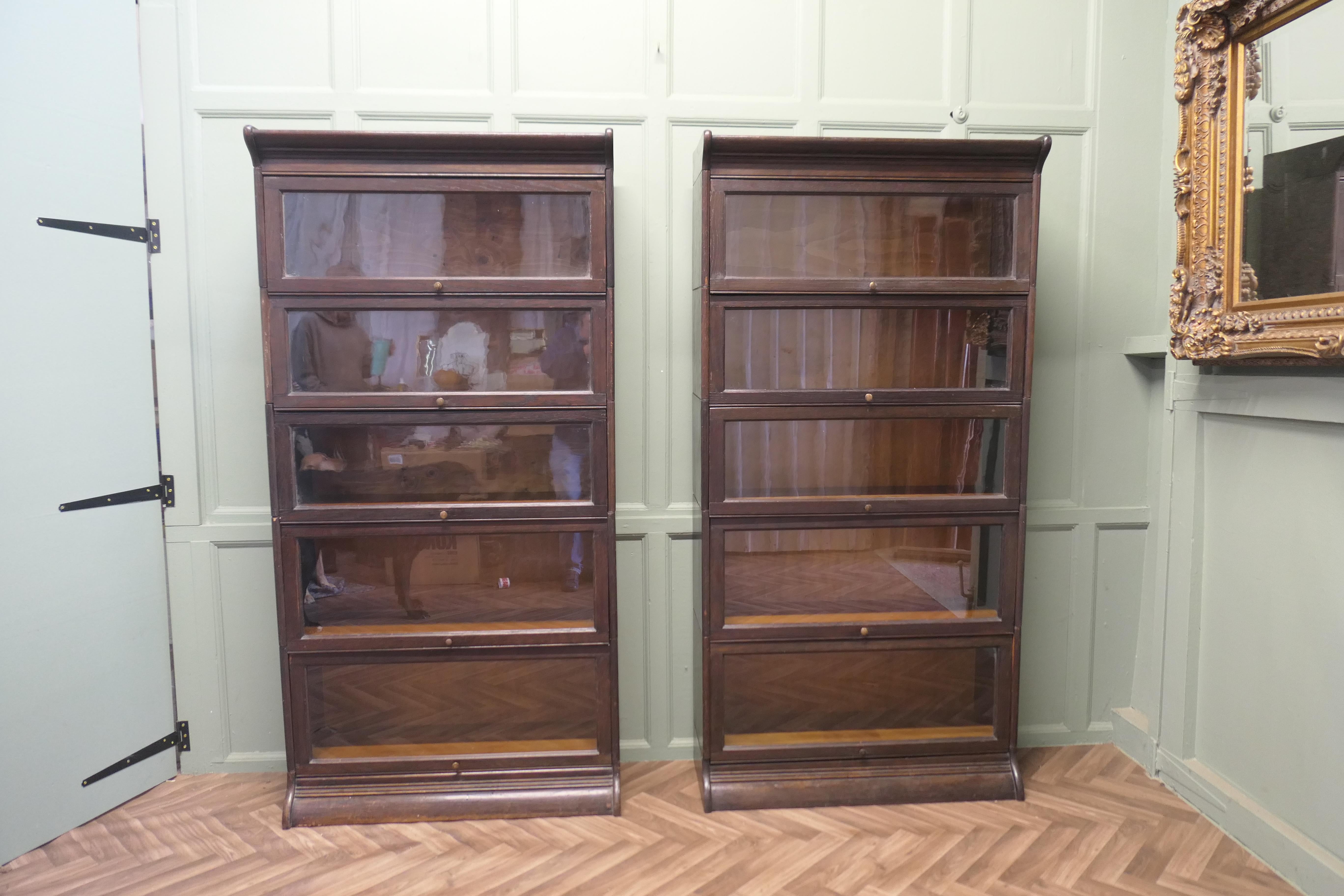 A Pair of 5 Stack Waterfall Oak Barristers Bookcases by Gunn

These are very tall Art Deco Bookcases both with 5 lift up glass fronted sections set on a shaped plinth 
The Bookcases are in good sound condition, this type of bookcase comes into many