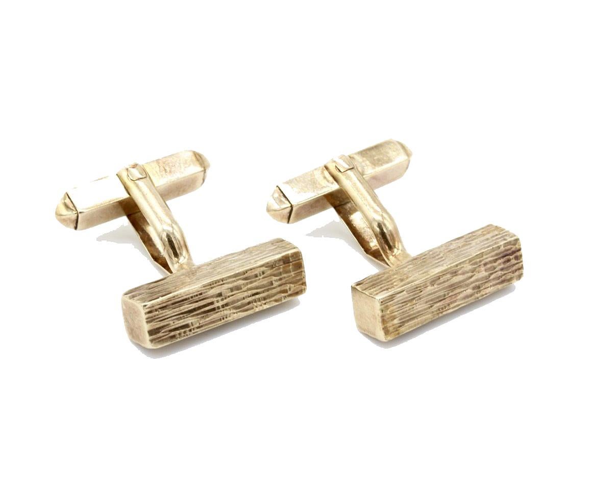 A pair of 9 Kt yellow gold bark effect baton cufflinks with swivel fittings.
Hallmarked 9 kt London 1978