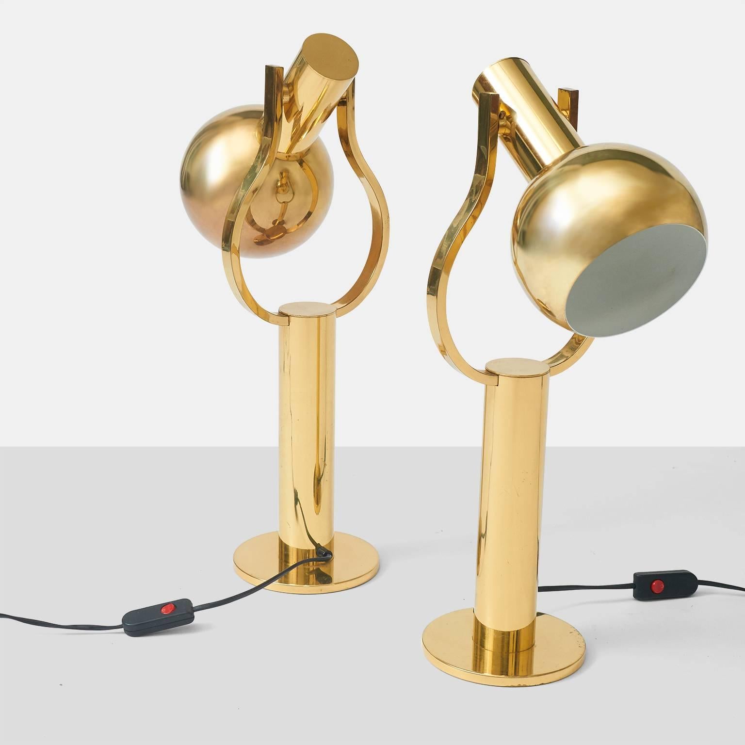 A pair of brass table lamps with shades that adjust 180 degrees to aim the light in multiple directions. Made in Germany by Staff. Each lamp will take a 60 watt bulb.