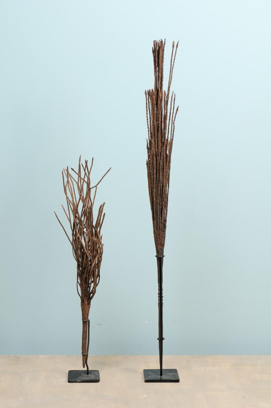 A pair of African Mumuye rain wands on custom stands. This pair of vintage tribal rain wands originate from the Mumuye peoples of West Africa, Nigeria. These forged-iron wands were utilized by the Mumuye shamans in rain-making ceremonies where they