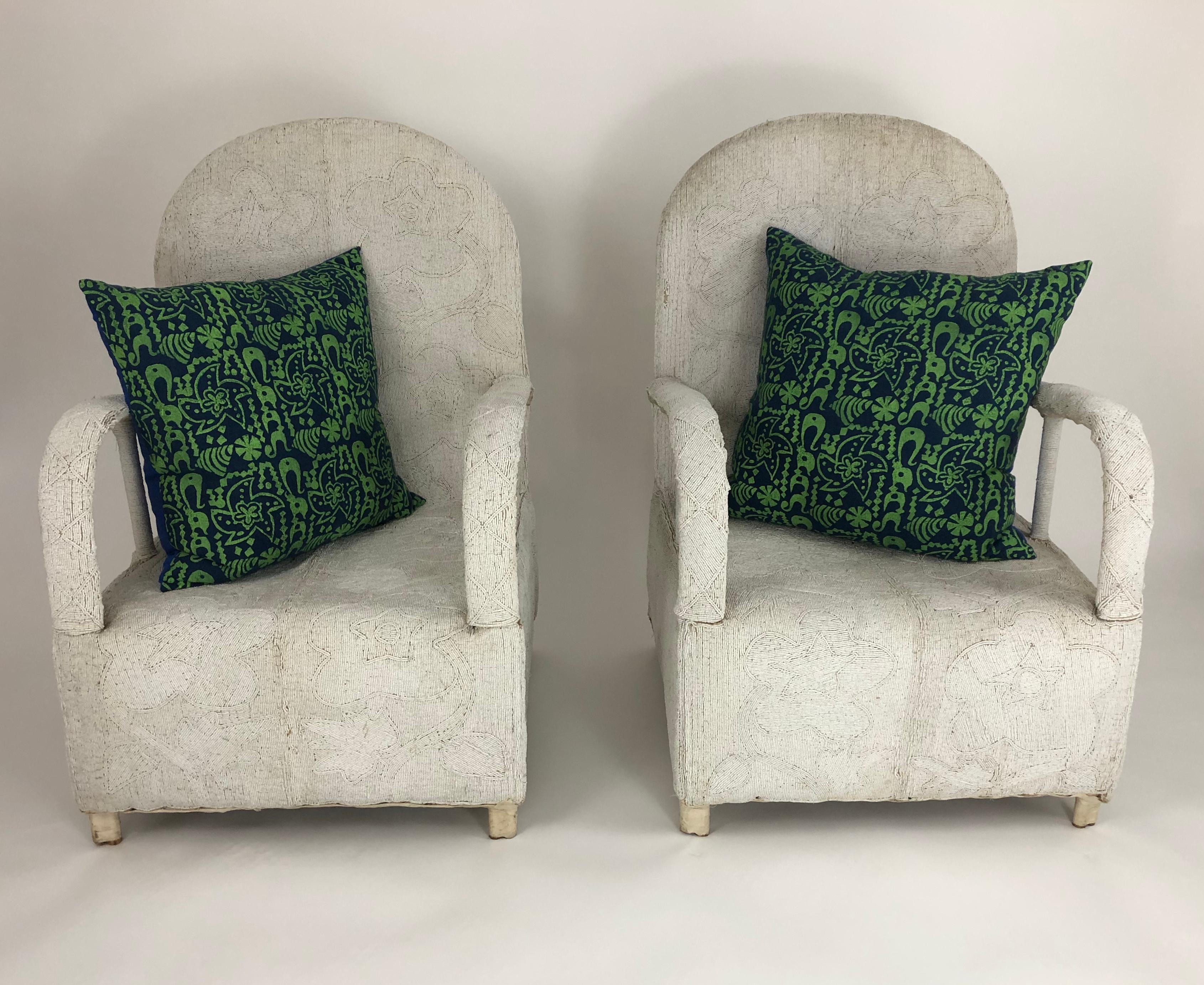 A pair of beautifully handmade African beaded lounge chairs by the Yoruba People, Nigeria. Originally reserved for Yoruba Royalty, these sculptural and comfortable chairs are decorated overall with small white beads. Completely handmade, these
