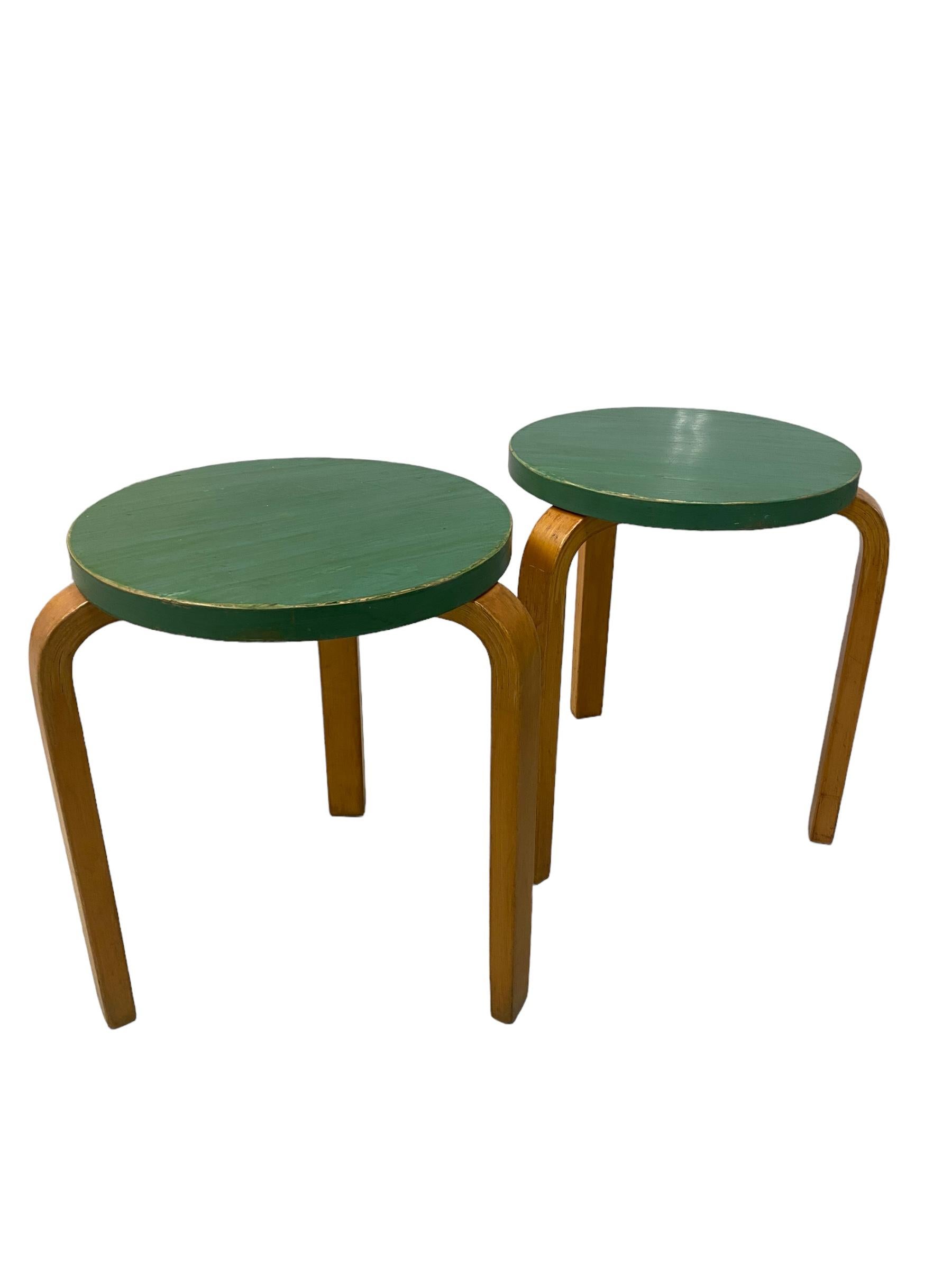 An iconic pair of green model 60 stools in birch. Designed by Alvar Aalto for Artek in the 1940s, this simple design has definitely stood the test of time, as it is still in production and is still one of the most popular among consumers. The model