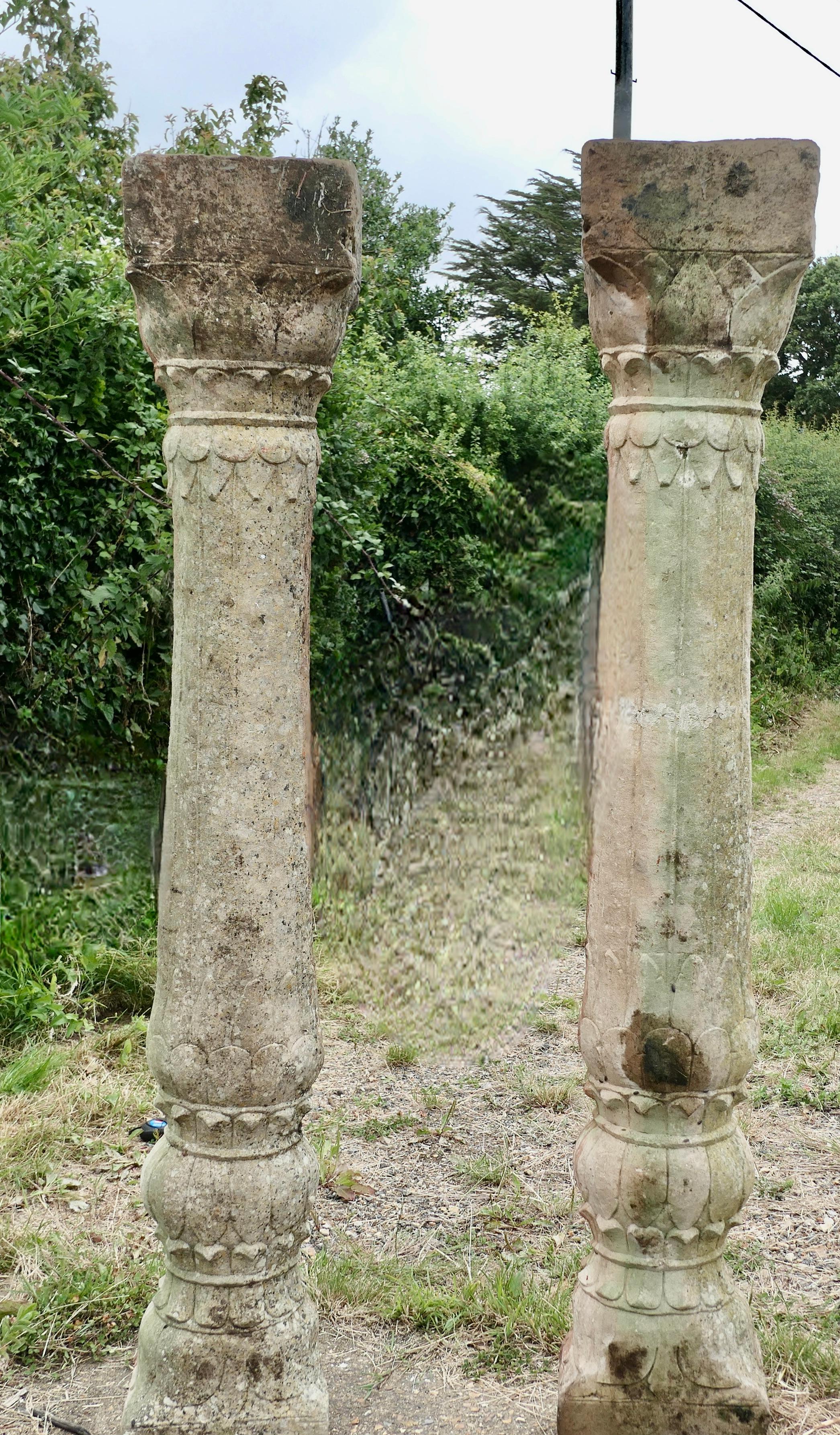 A Pair of Ancient Corinthian Type Stone Columns, 

These are a very heavy pair of Hand Hewn Stone Pillars, they are very well weathered and probably originated from a Portico

The Columns are decorated in a slightly reeded style with leaf shaped