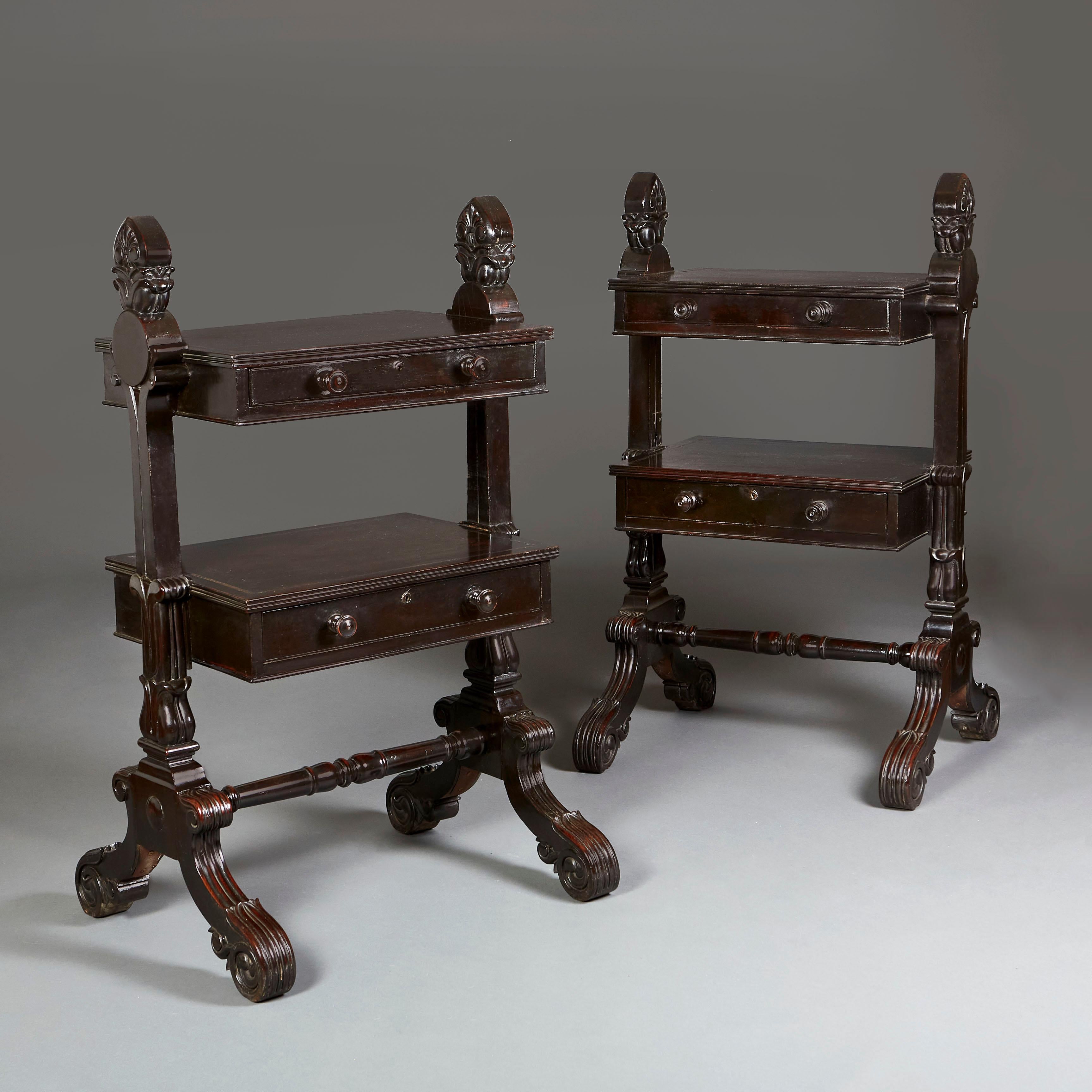 A pair of unusual early nineteenth century Anglo Indian etageres, of ebonised timber, with two floating drawers, boldly carved acanthus finials, supported on splayed legs joined with a cross stretcher.
