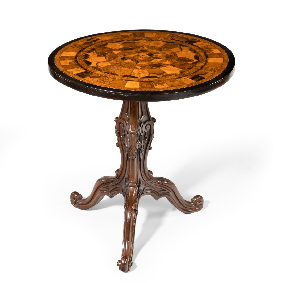 A pair of Anglo-Indian specimen top occasional tables, each with an octagonal top inlaid with hexagons of exotic and petrified woods cut across the grain, within an ebony border, set upon a walnut baluster support carved with strapwork, acanthus,