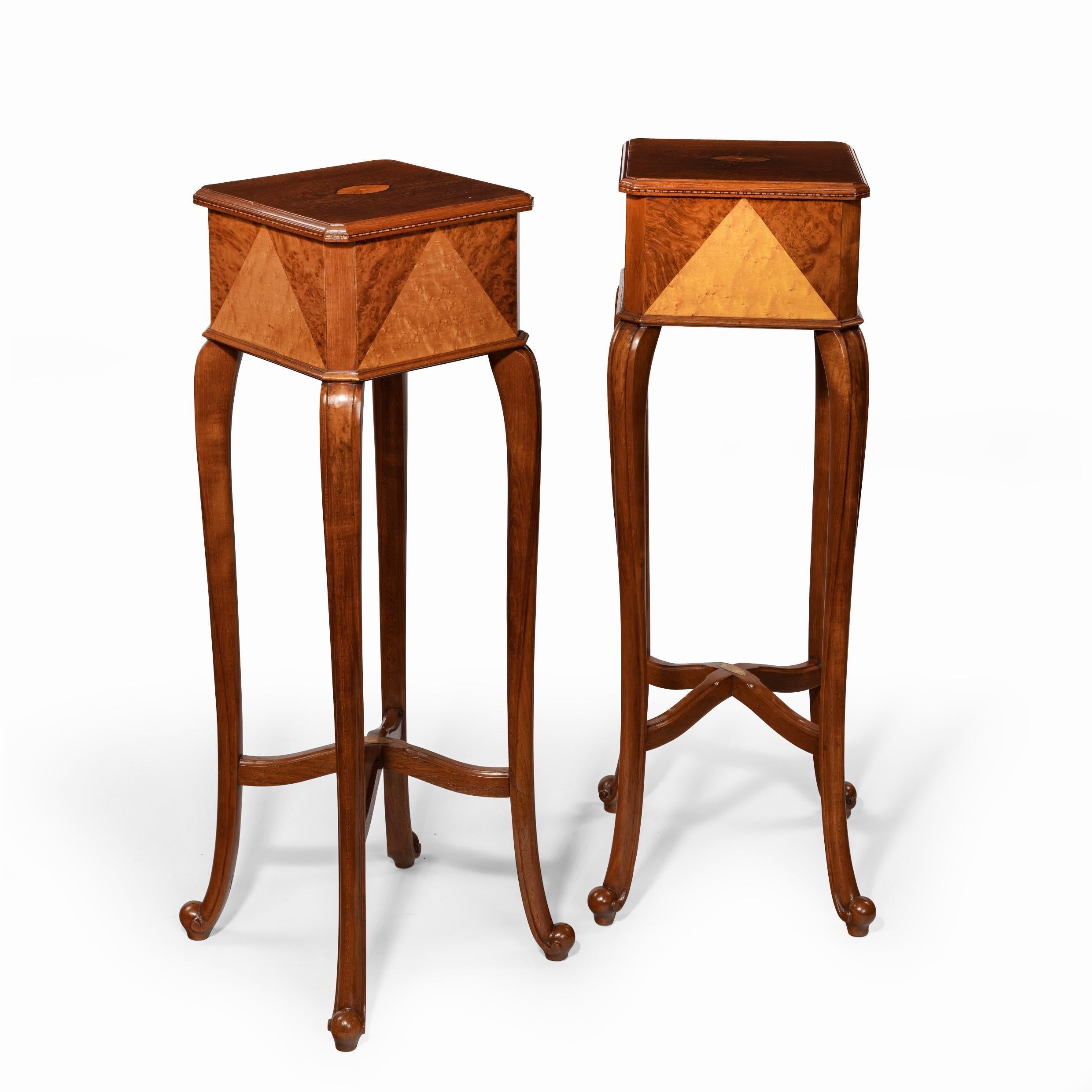 A pair of Anglo-Indian teak stands, each of square form raised upon four cabriole legs, the decoration comprising bold triangles of contrasting exotic woods, with an oval brass plaque reading ‘Navroji Dadabhoy & Co, Bombay, Cabinet makers’. Indian,
