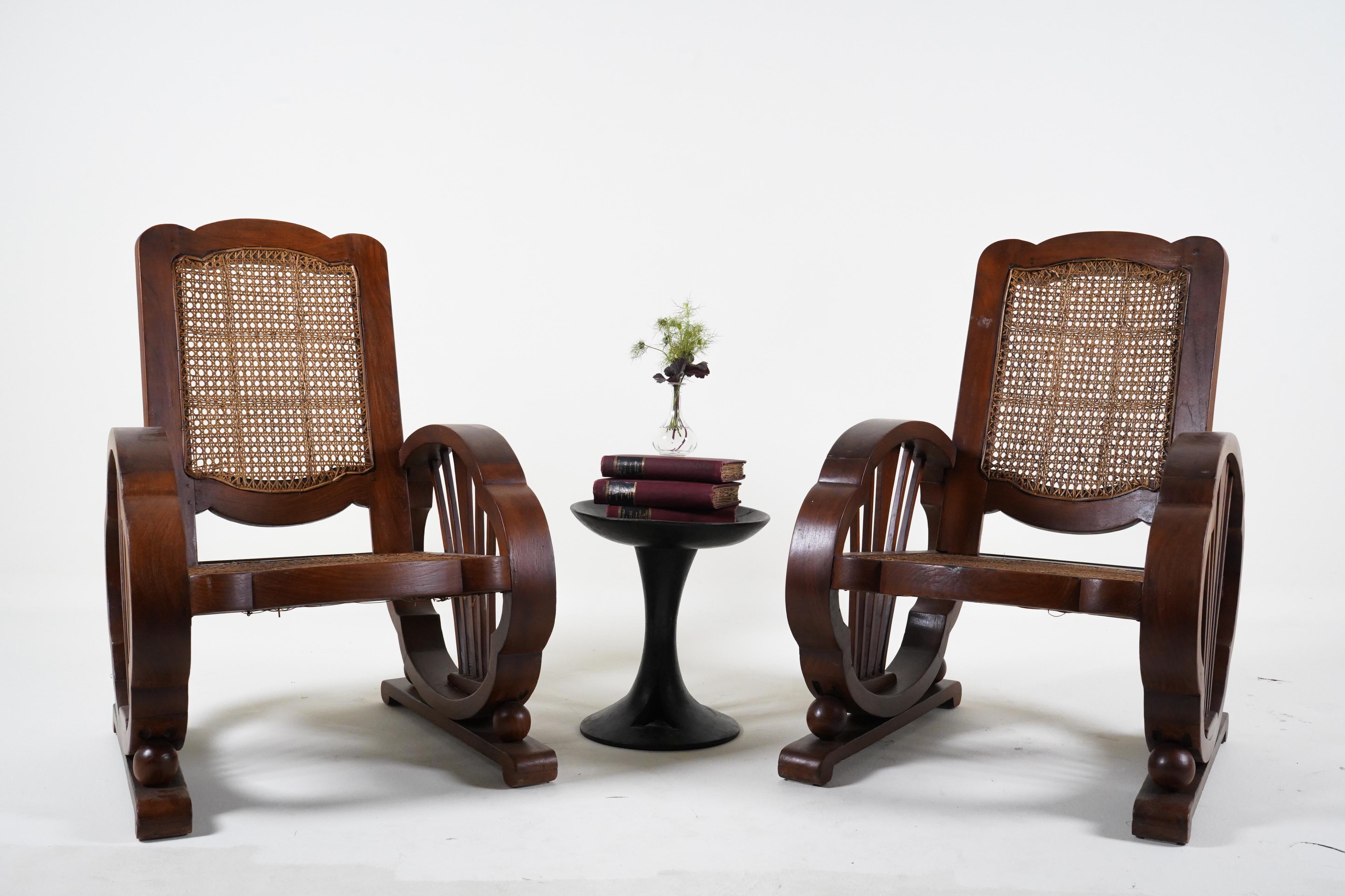 These stylish lounge chairs date to the 1920's and were made in Rangoon, Burma. During the British Colonial period, much Indian furniture was made following British or European styles. High quality native hardwood was used, such as Teak and Rosewood