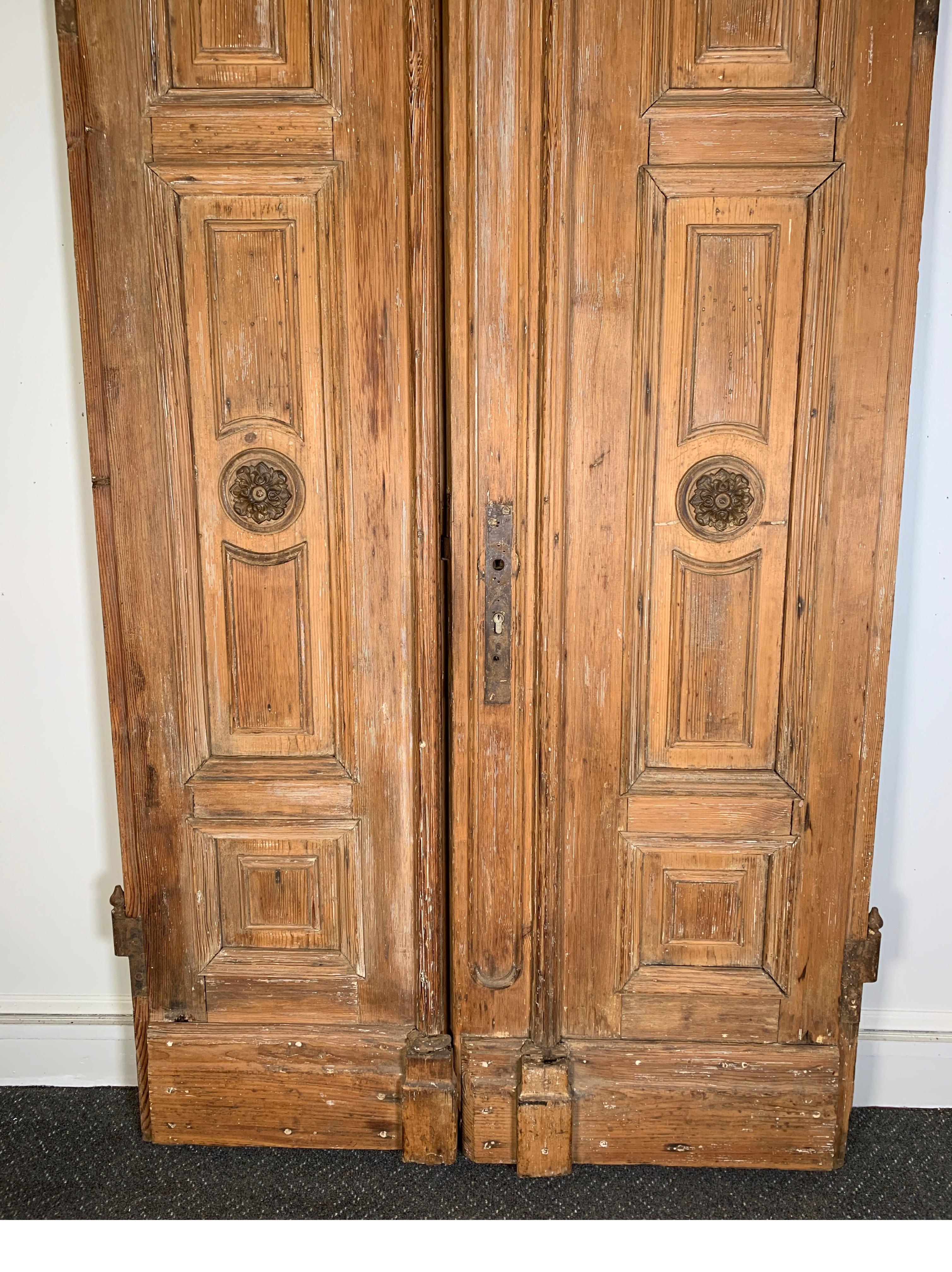 A remarkable pair of 19th century handmade solid pine doors, England, 1860-1880. These beautiful doors at 92.5 inches tall, 49.5 inches wide with exceptional workmanship with a natural scrubbed finish. Notice the zinc capital detail at the top,