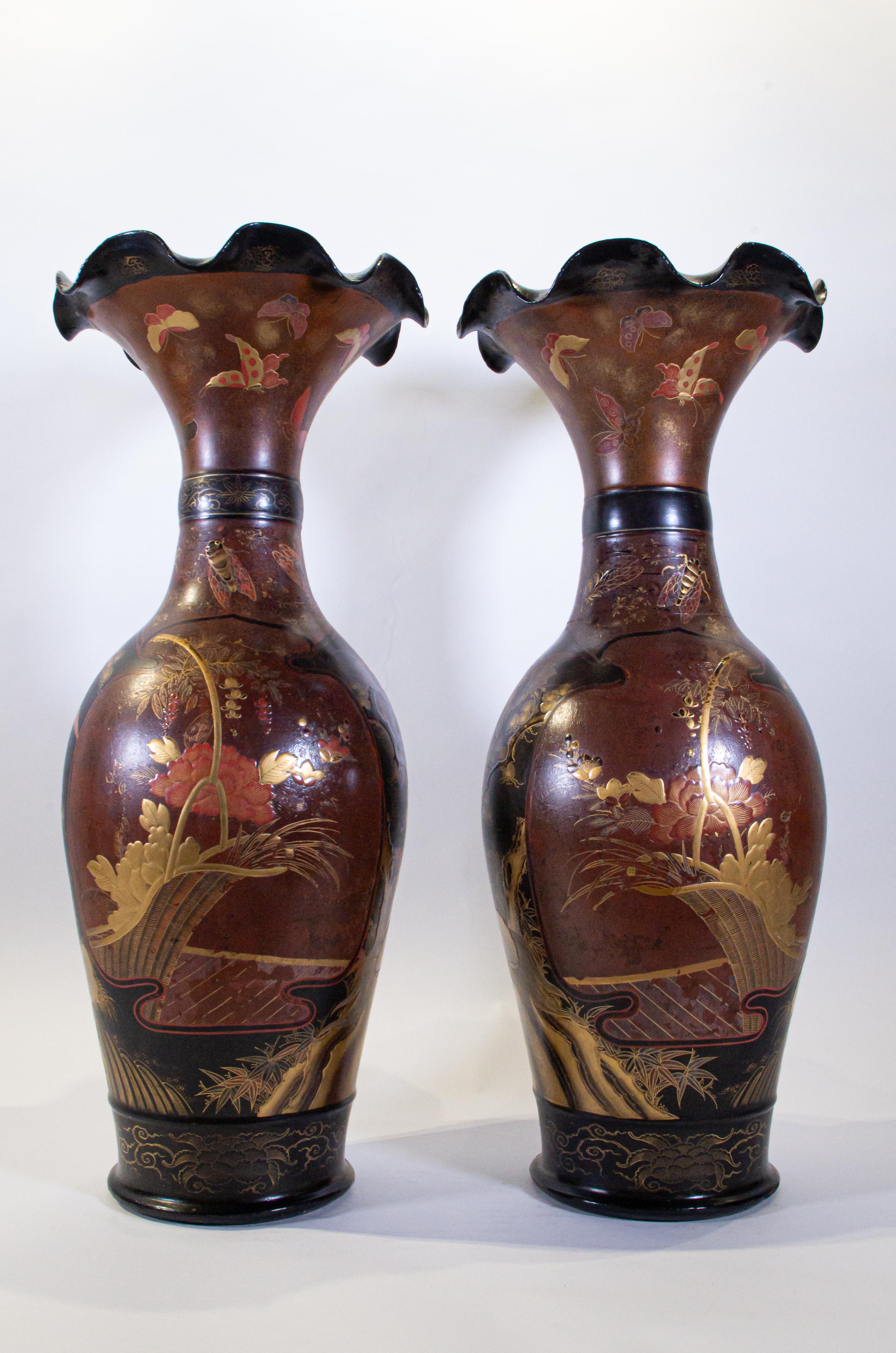 A monumental and unusual pair of antique 19th century Japanese porcelain poly-chrome lacquered vases. Each is beautifully designed with koi fish, butterflies, trees, mystical beasts, chrysanthemum flowers, insects and clouds. All decorative aspects