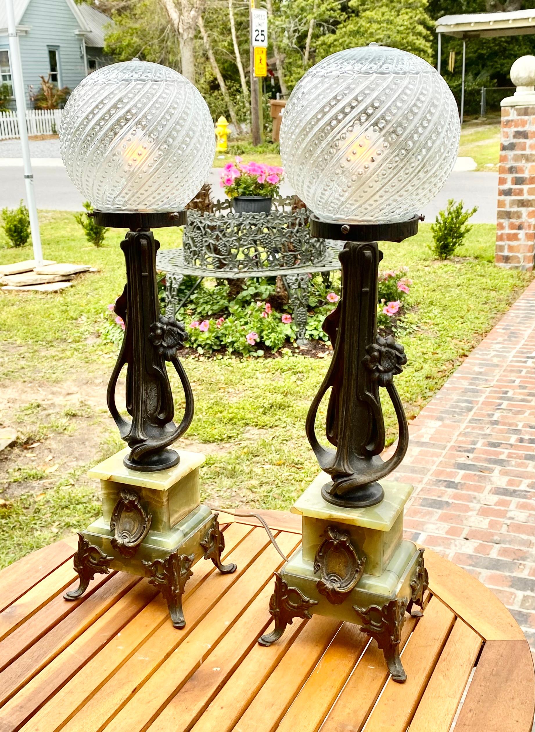Paar französische Jugendstil-Tischlampen aus patiniertem Zinn und Onyx, 19. Jh., früher Öllampen, mit runden, mundgeblasenen Glasschirmen auf einem Jugendstilträger aus Zinn und einem abgestuften Sockel aus grünem Onyx, auf gespreizten