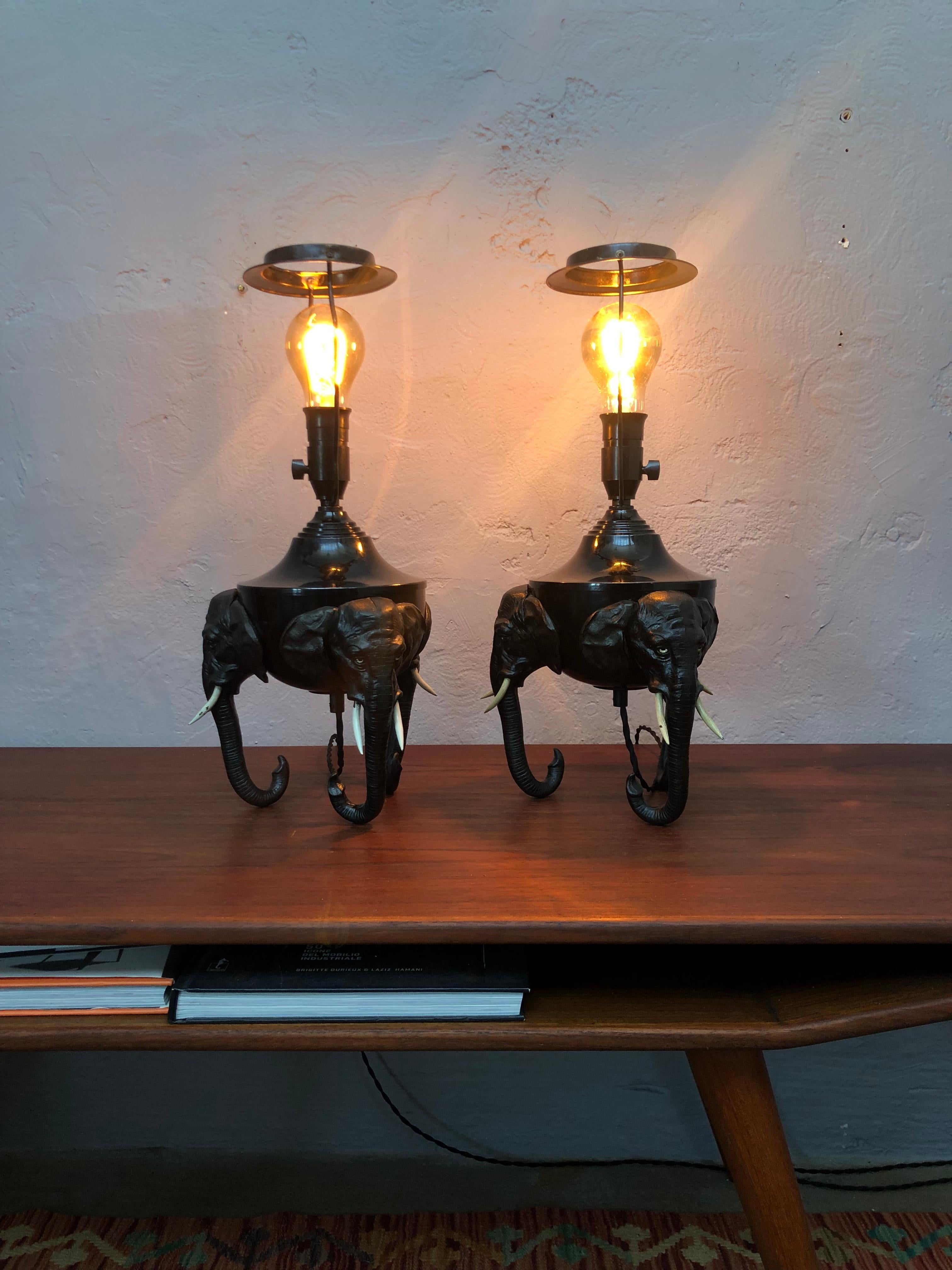 A pair of rare antique Danish elephant lamps from the 1920s.
Raised on 3 elephant heads of cast iron with white painted iron tusks.
The elephant heads are attached with two screws to a black painted brass vessel that originally would have been