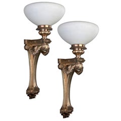 A pair of antique bronze uplight sconces