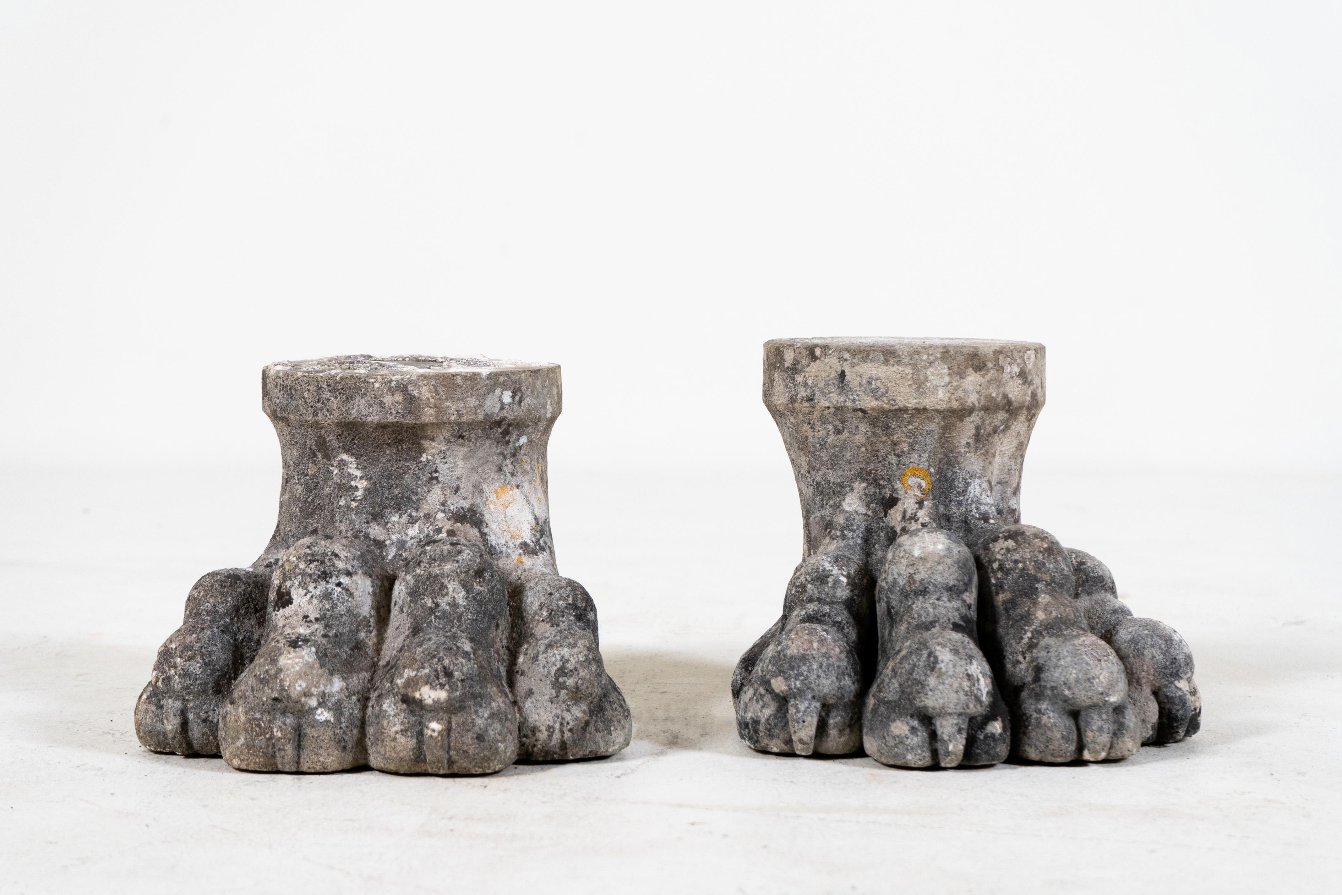 A very large pair of cement lion paws. It's unclear whether these impressive paws were made as playful garden stands or were part of a larger sculpture. They are in excellent condition with a pleasing grey patina enlivened by blotches of yellow