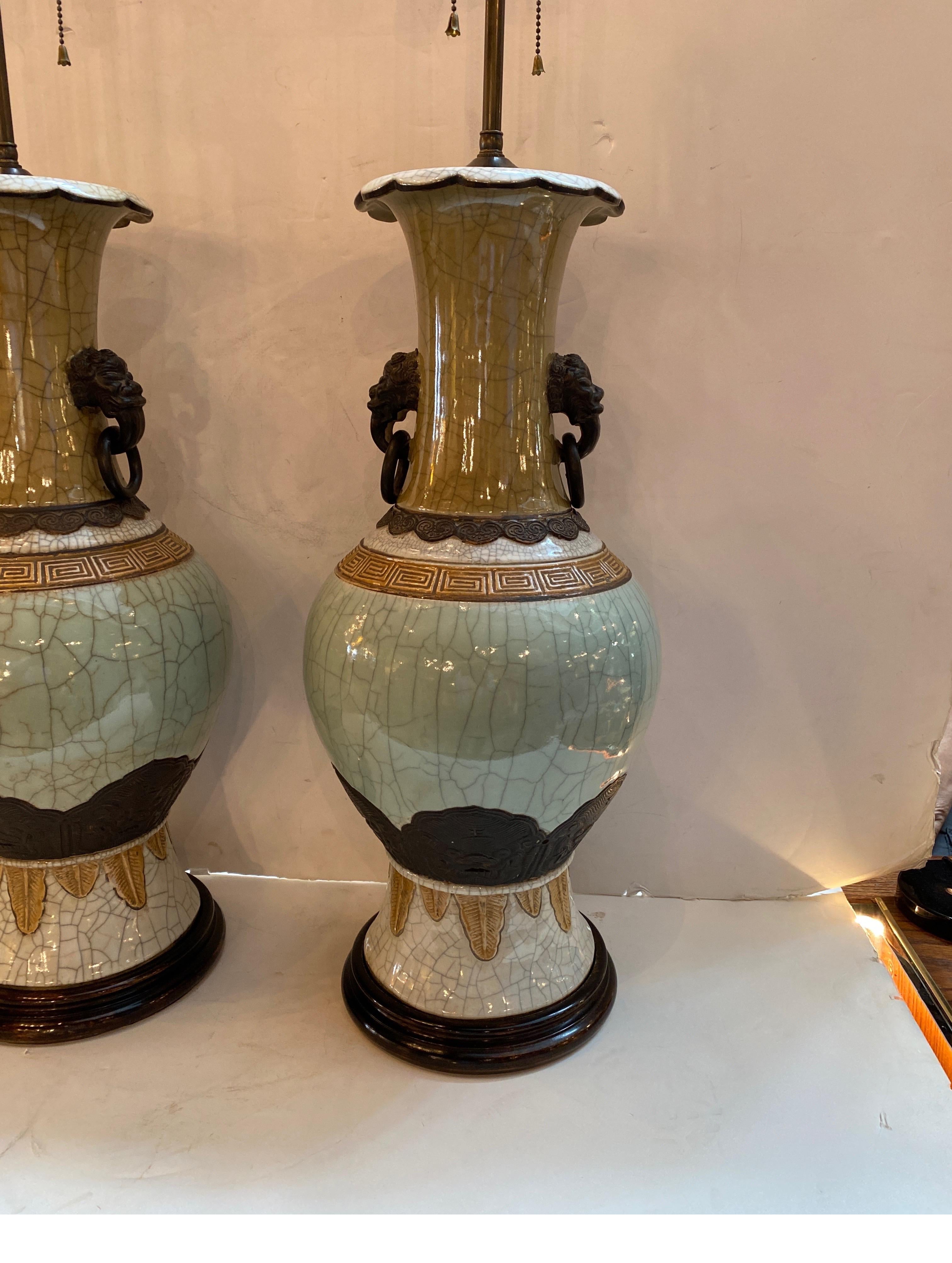 A pair of Antique Chinese celadon porcelain vases now as lamps. The vases with a crackle glaze with ring and mask handle mounts with all new hardware.