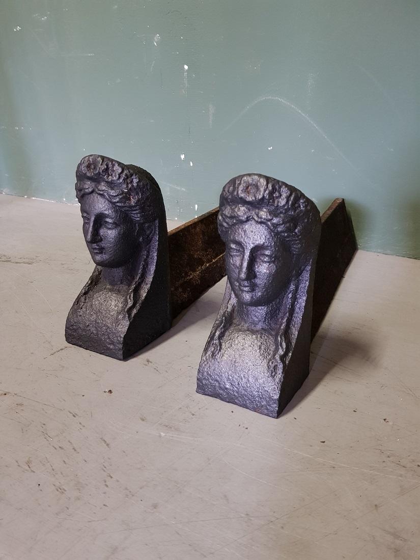 Set French antique cast-iron fire-goats on which the logs are laid in the fireplace, both have a woman's head at the front for decoration, both are in good but used condition. Originating from the second half of the 19th century.

The measurements