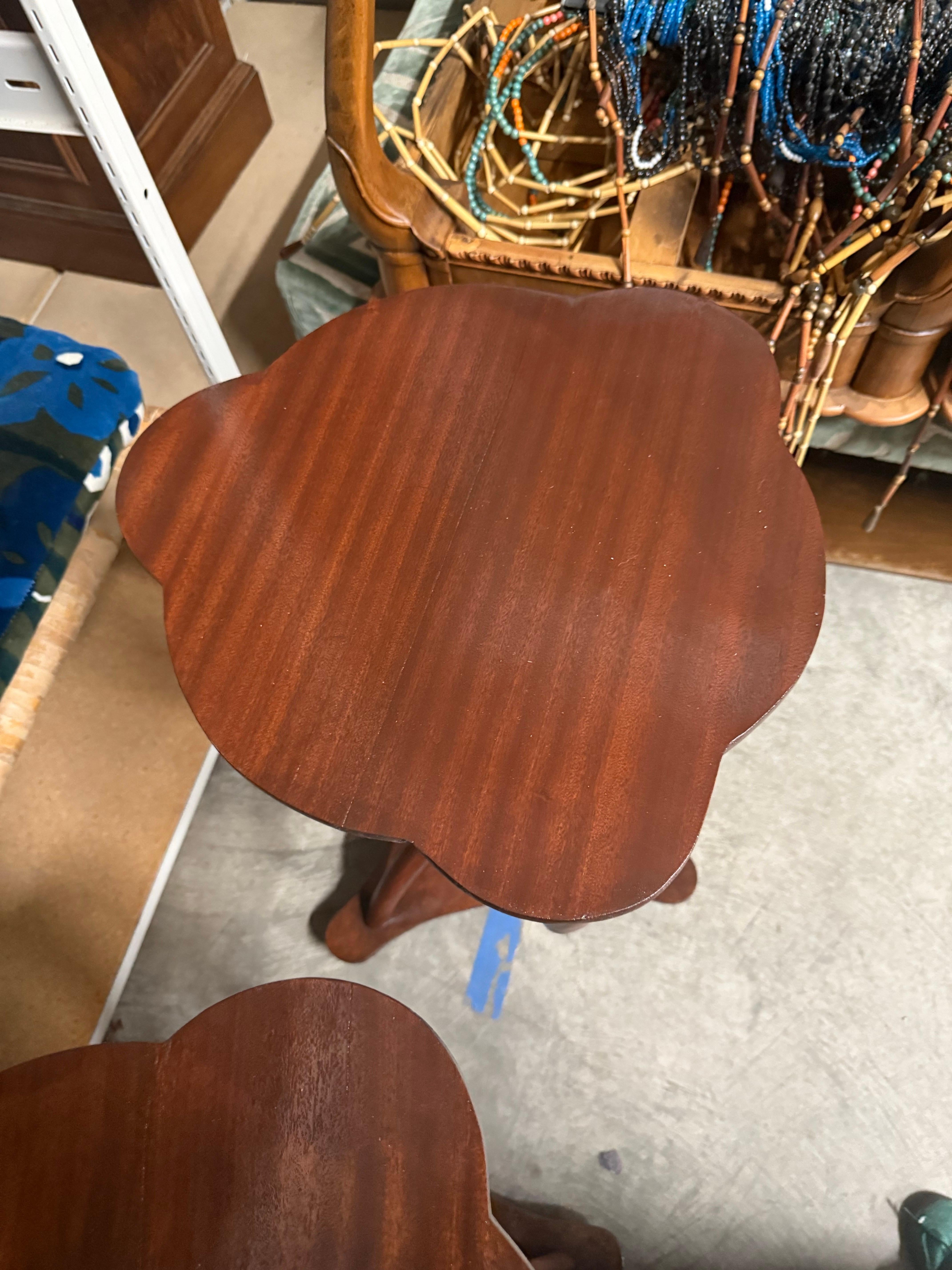 This unique French side table features Art Deco styling with its interesting base crafted with three curved and twisted wooden legs which attach to a triangular base atop three ball feet. The top and apron feature a scallop edge and pack a lot of