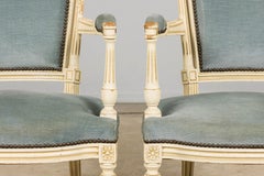 Una coppia di poltrone dipinte in stile Luigi XVI francese in velluto blu