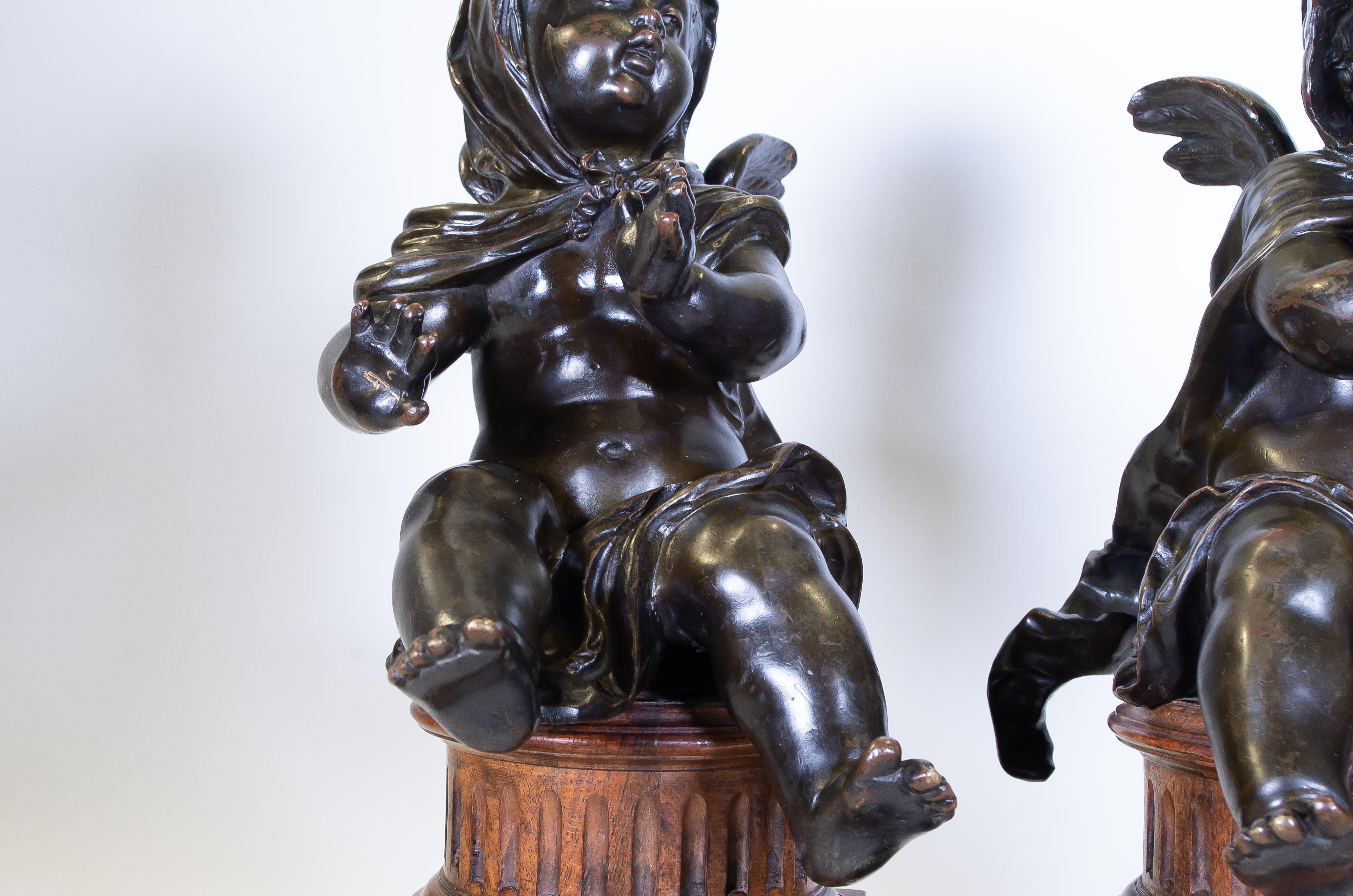 Late 19th Century Pair of Antique French Patinated Bronze Winged Putti Seated on Fluted Plinths For Sale