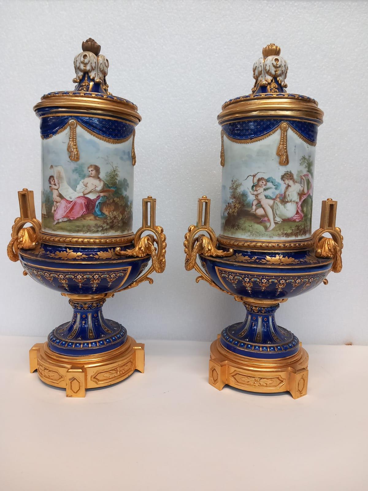 A  pair of antique French Sèvres vases dating from the Napoleon III era. 
Decorated in the eighteenth century style with its blue enamel body and highlighted in gold leaf with hand enamelled designs made to resemble jewels. 
Both vases are hand