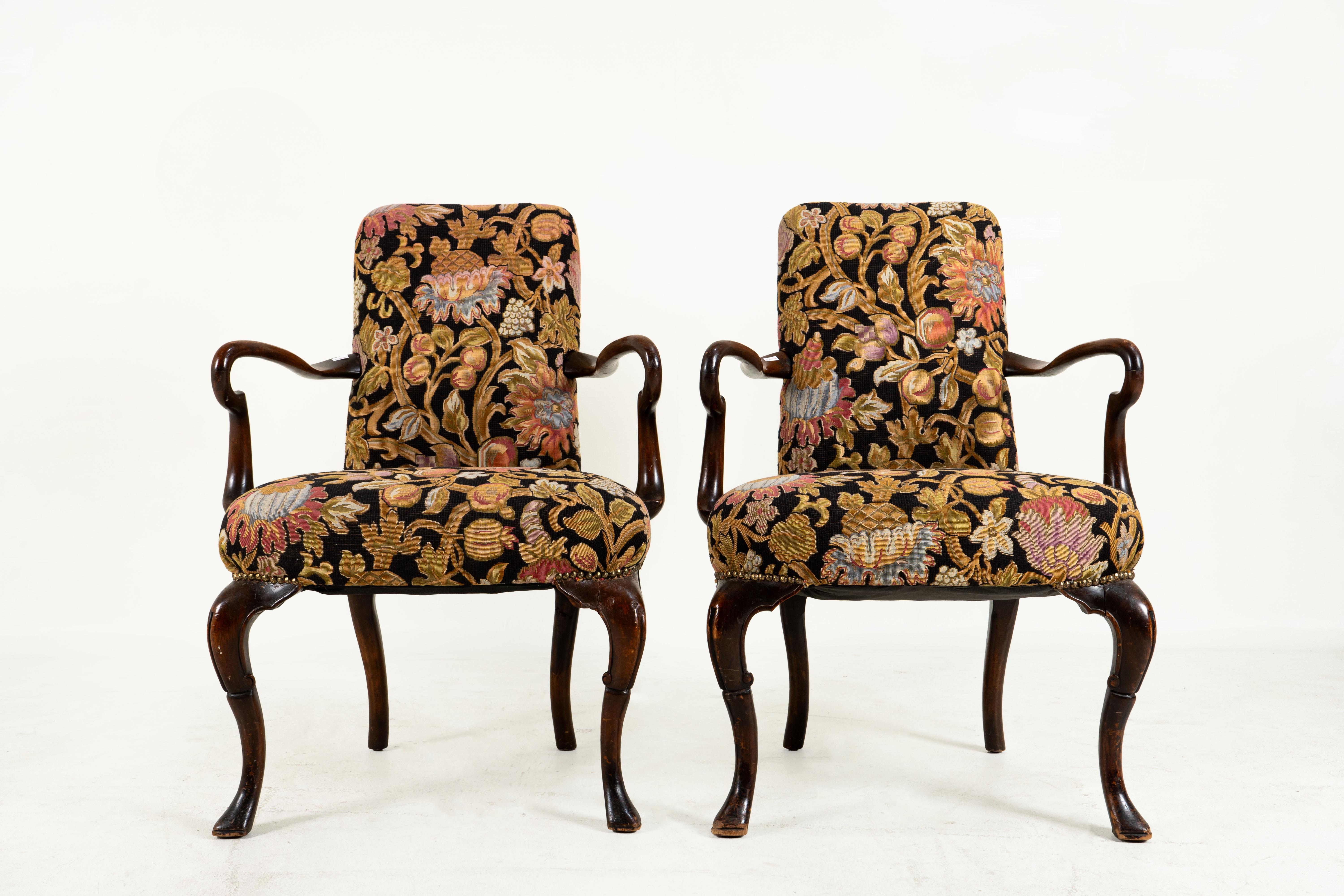 A graceful and fluidly elegant pair of early 19th century George I walnut shepherd's crook armchairs covered in antique needlework. These are simply exquisite examples of antique English furniture craft.  Because of their fine condition, we think