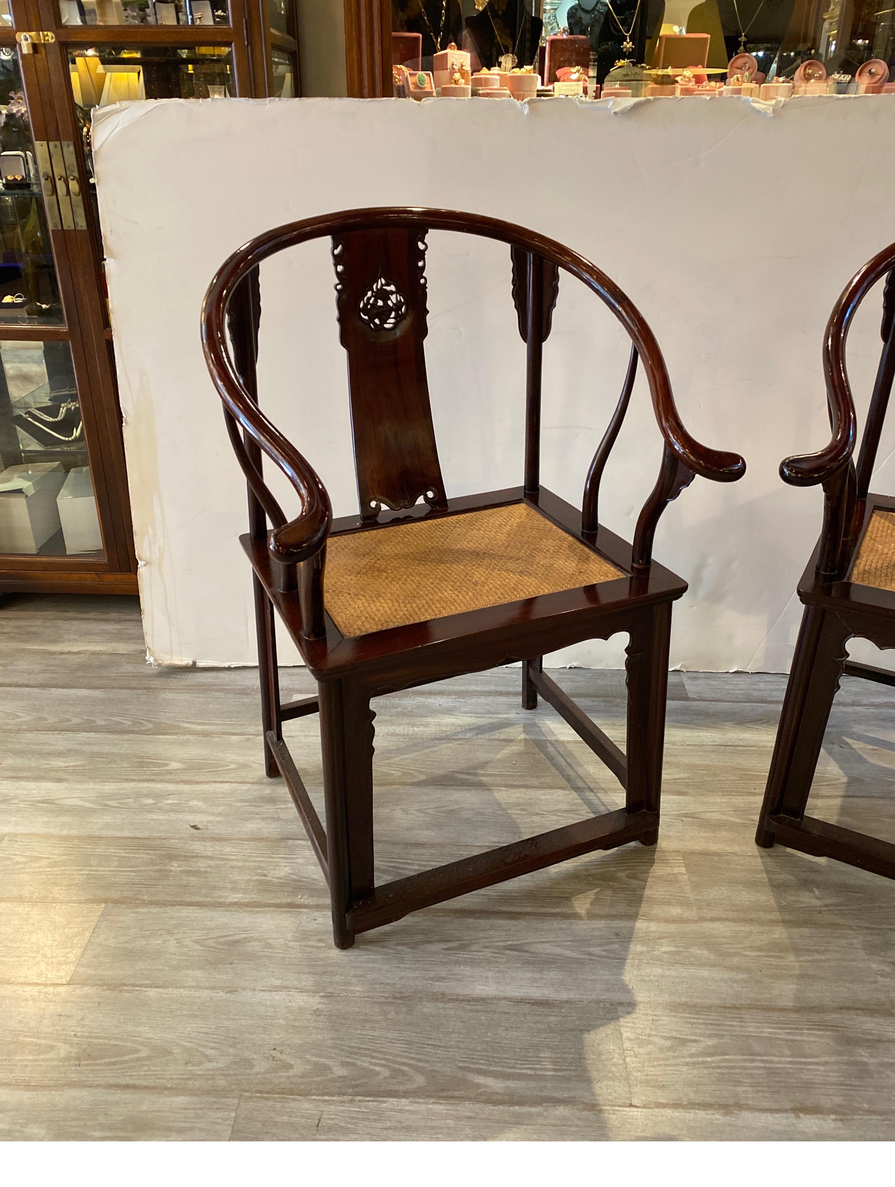 Elegant antique hand carved rosewood arm chairs. The splat backs with hand carved dragon cartouche. the continuous rail with gently flared ends. The seats with a hand woven wicker over a wood seat. China Circa 1900-1920.