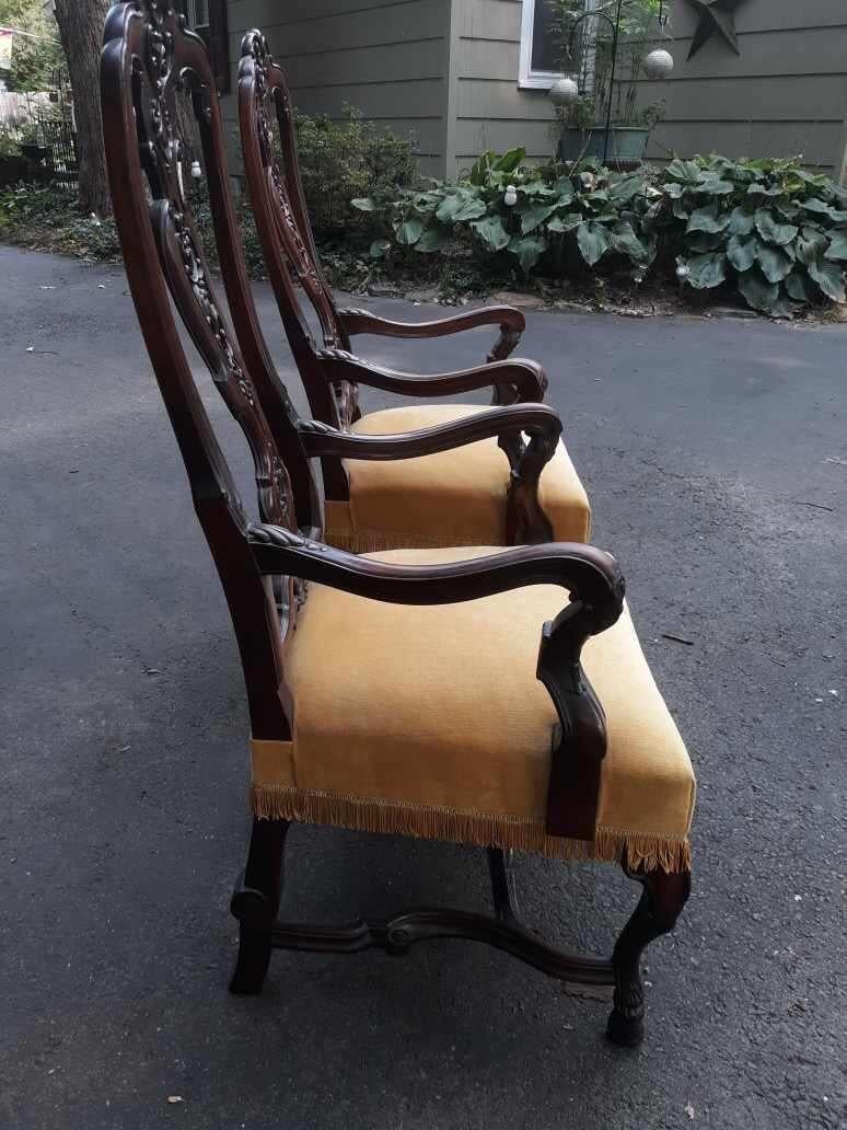 A pair of George I style hand carved English walnut armchairs. Both chairs wit recent pale yellow velvet upholstery on the exceptionally carved frames.
