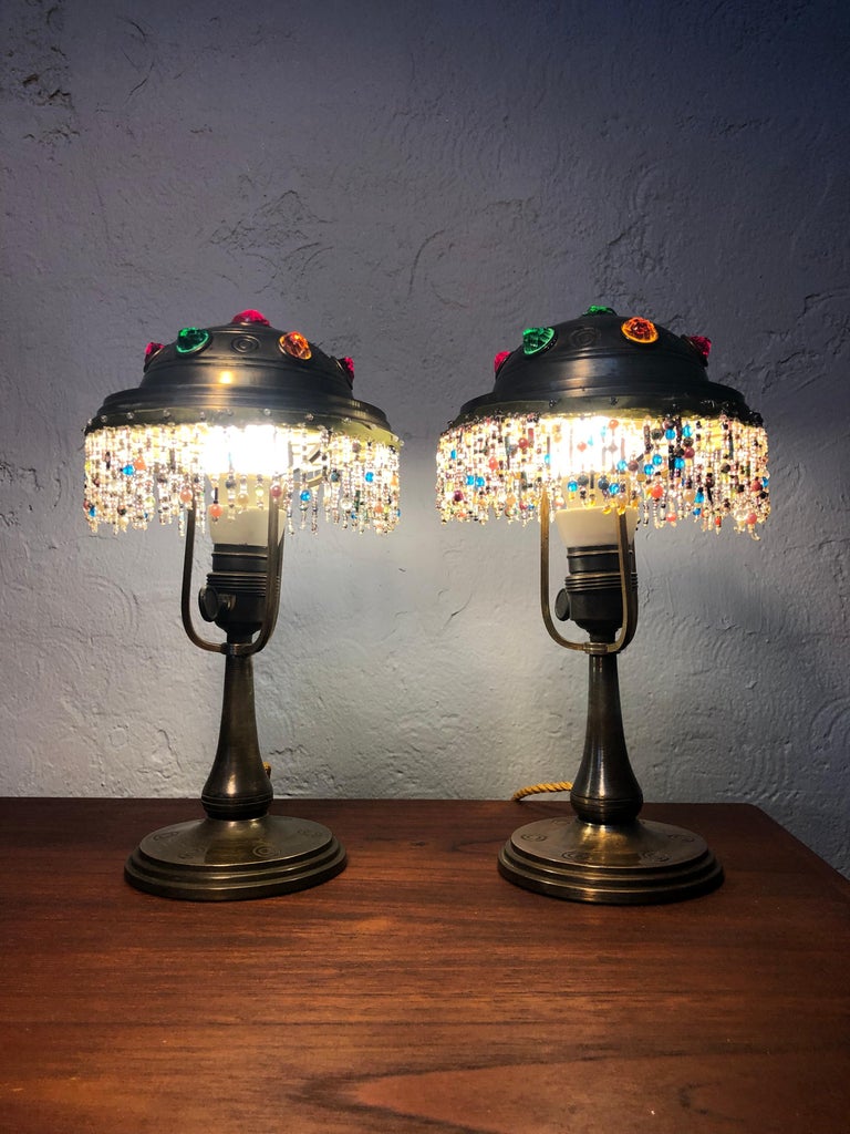 A Gorgeous pair of brass Jugend table lamps. 
Completely original condition from the glass beaded skirting on the brass shades to the glass cabochon pearls and also the brass and porcelain bulb holders with on/off switch. 
This pair of Jugend