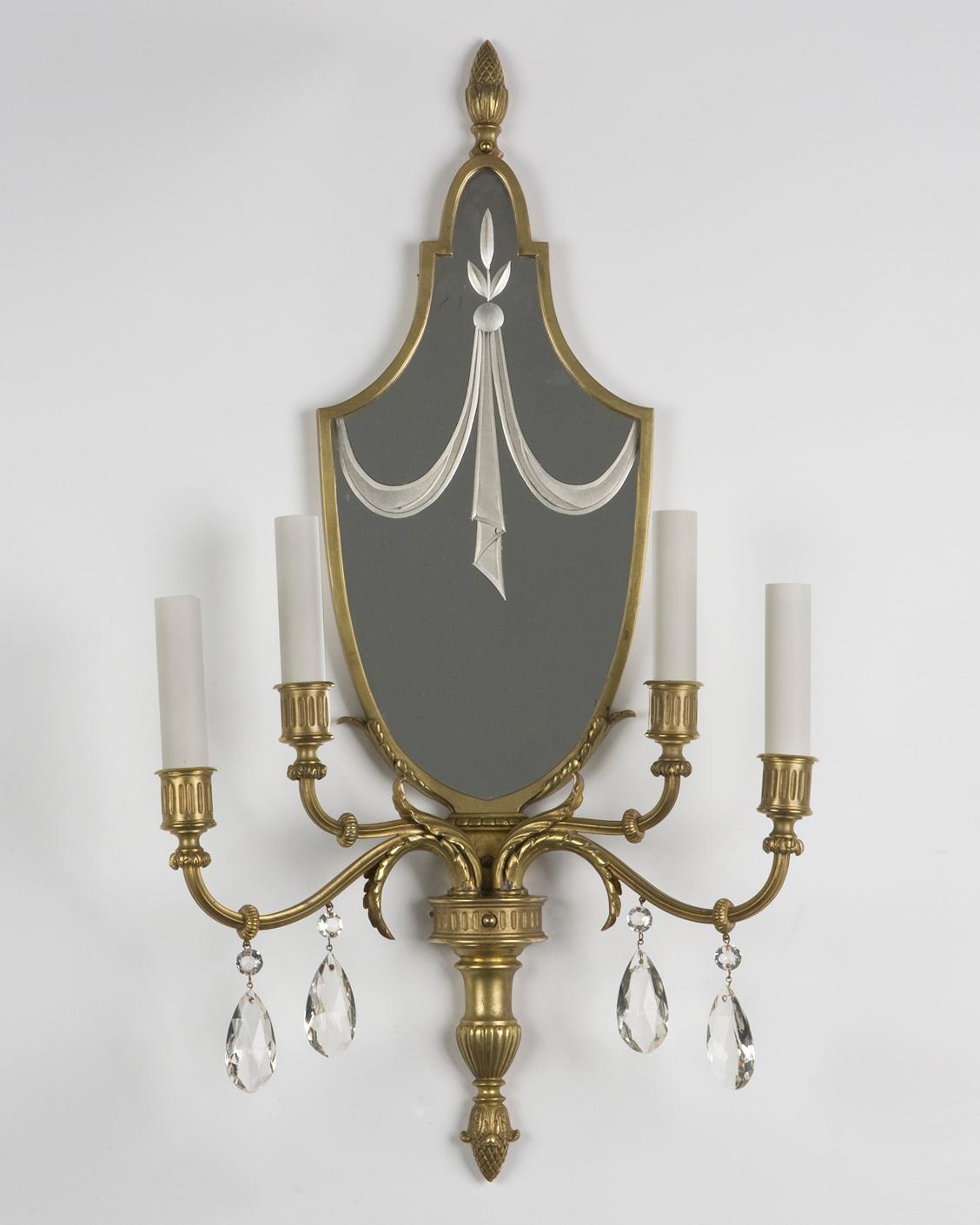 AIS1880
A pair of antique four arm sconces in old warm brass, with wheel-cut mirrored backplates. The arms dressed with faceted crystal prisms. From the Henry Ford Museum in Dearborn, Michigan.

Dimensions:
Overall: 27-1/2