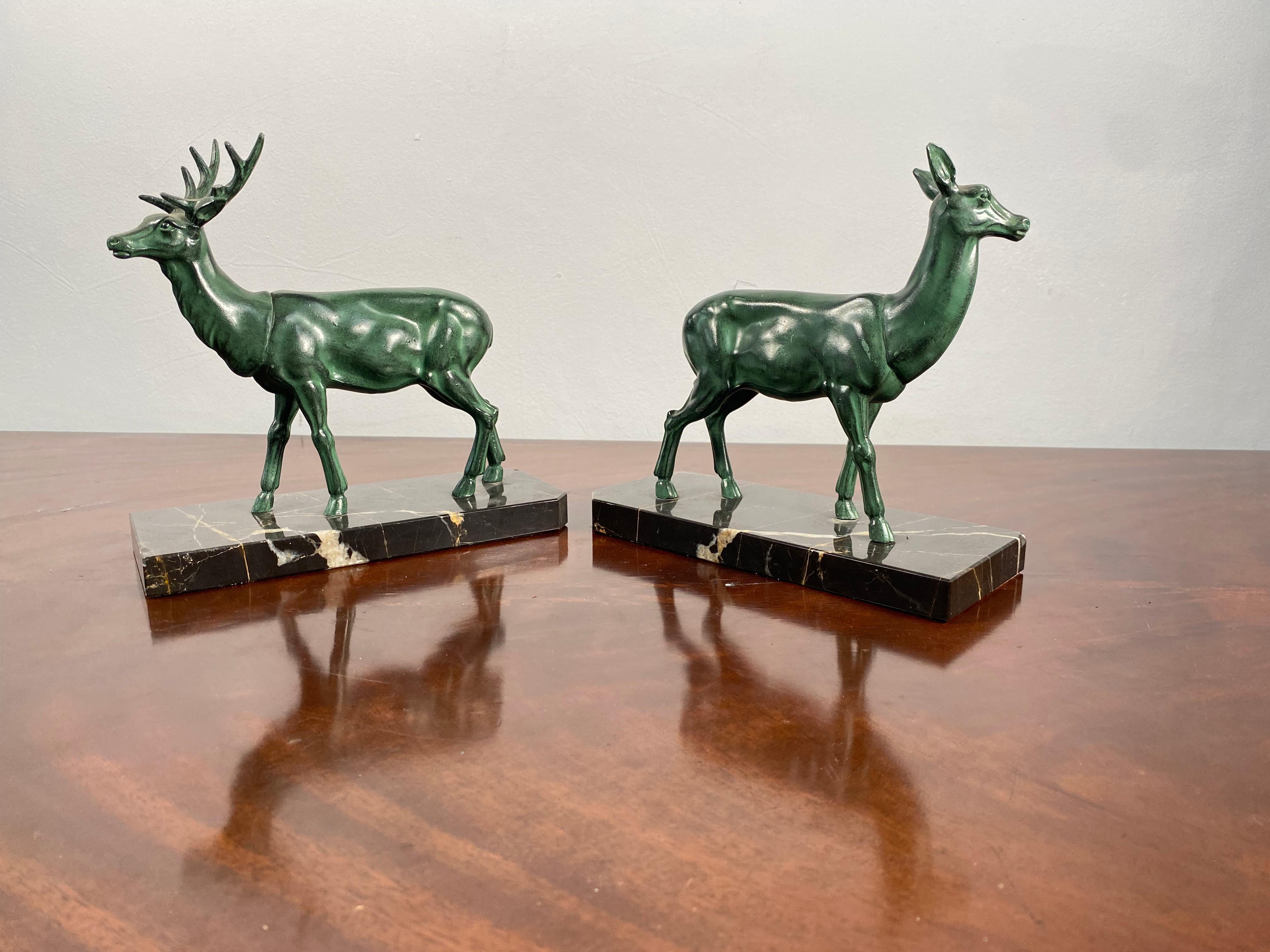 A lovely pair of french art deco bronze and marble bookends, depicting a male and female deer.