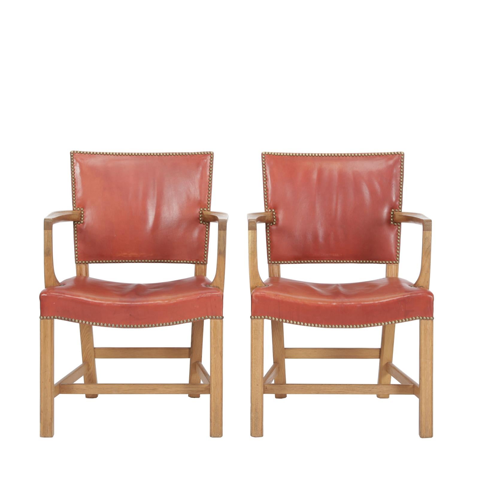 A pair of armchairs in oak with original red leather and brass studs.
Designed by Kaare Klint in 1930. Made by master cabinetmaker Rud. Rasmussen, Denmark.