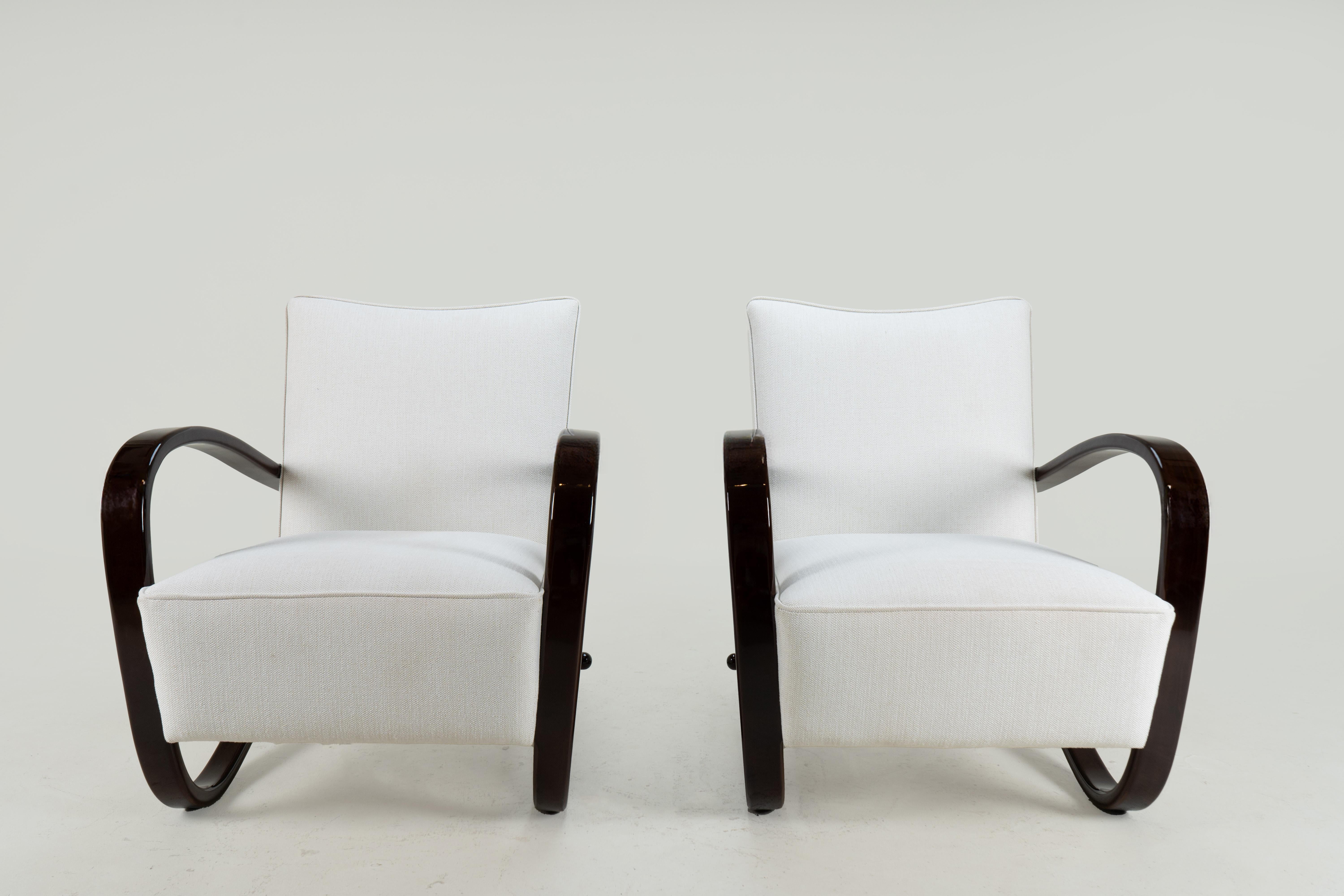 These sinuous and stylish armchairs are made in the style of Jindrich Halabala, a Czechoslovakian furniture designer and maker from Prague. Halabala was a design innovator very much influenced by the Bauhaus.   His furniture was modern,  original