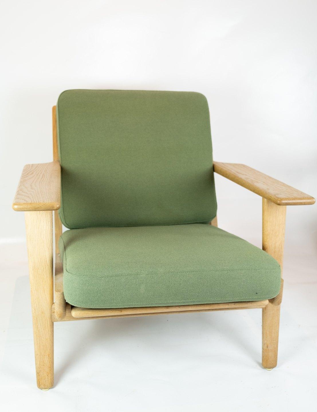A pair of armchairs, model GE290, designed by Hans J. Wegner and manufactured by GETAMA in the 1960s. The chairs are of oak and cushions of light green wool.
   
