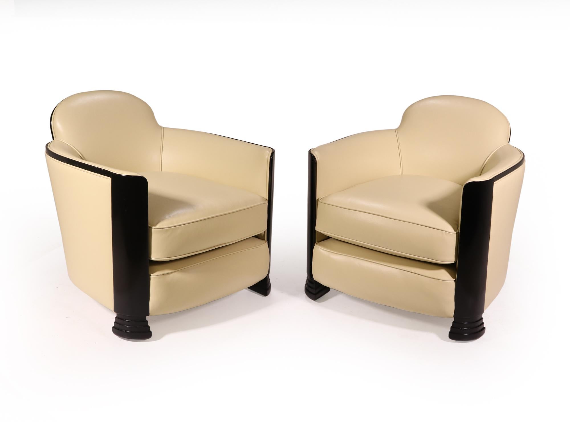 A pair of armchairs produced in the 1930’s in the manner of Jules Leleu the chairs have stepped front fee with curved front uprights and show wood trim that has all been recently polished and is in exceptional condition. The chairs have been fully
