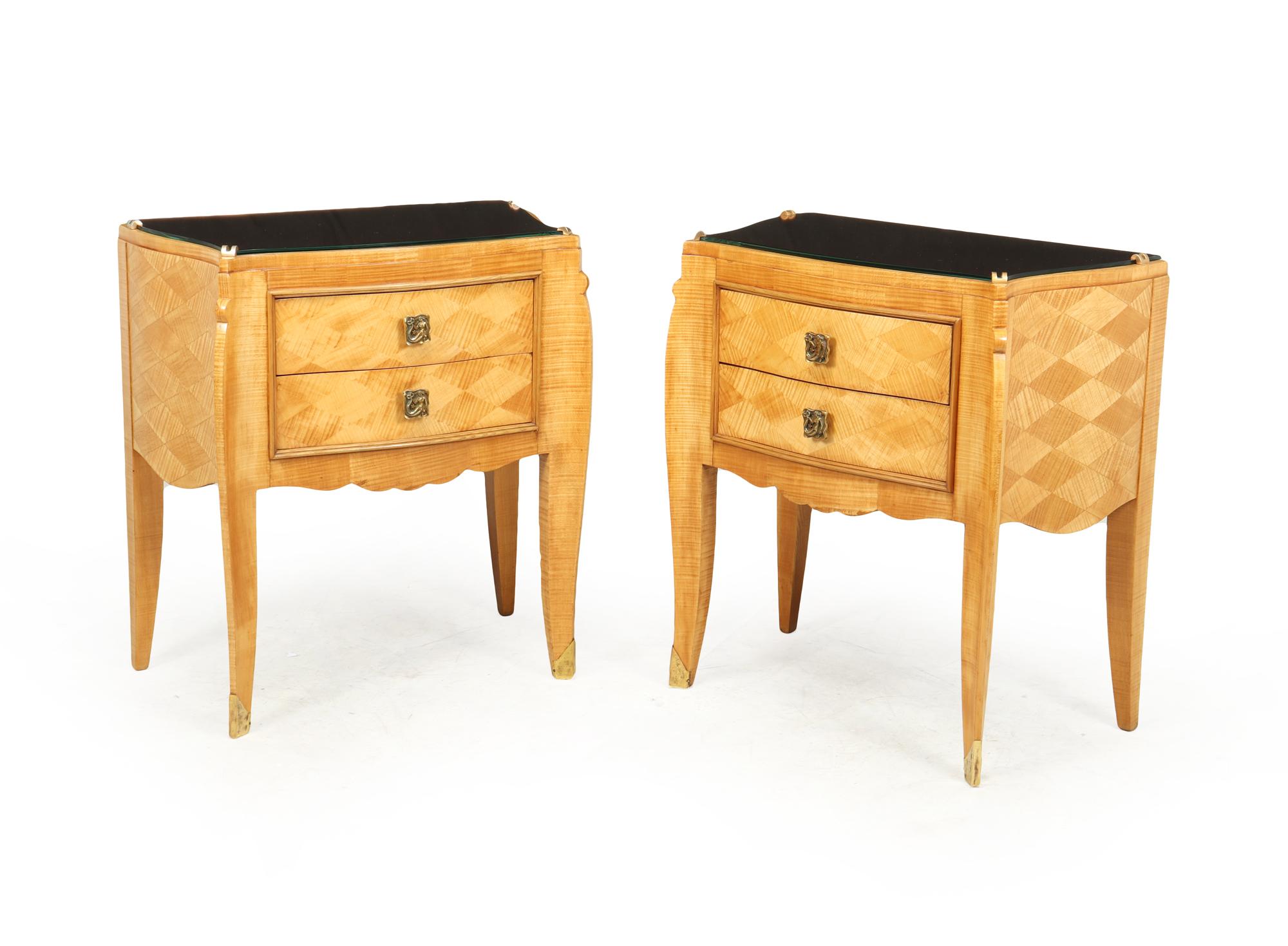 A serpentine shaped sides and front pair of two drawer chests with saber legs covered in sycamore parqutry veneer and having peach mirror tops designed and produced in Paris by Jules Leleu

The chests are of exceptional quality and have been fully