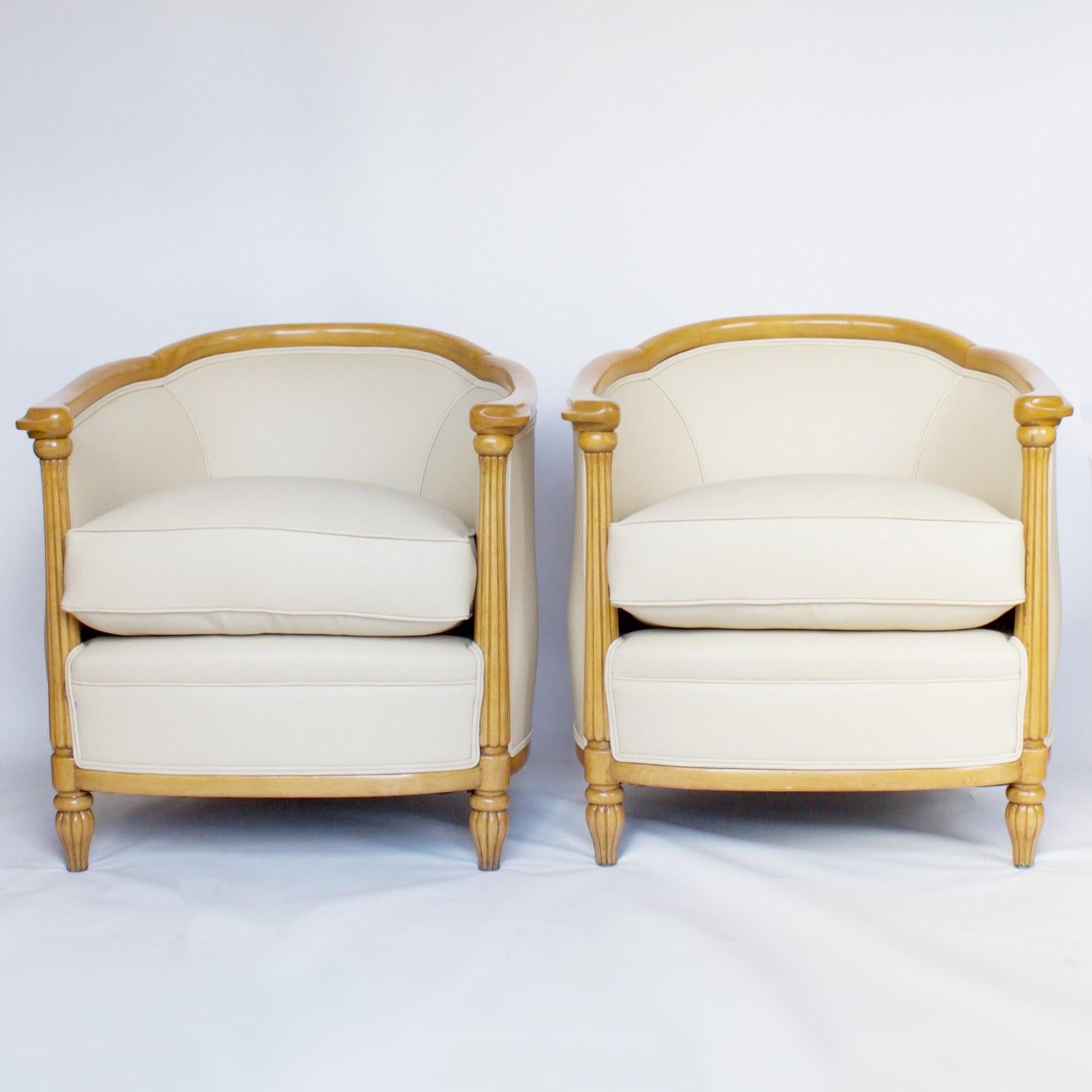 A pair of Art Deco tub chairs with reeded front column legs and curved frame with carved hand rest detail. Solid beech wood, upholstered in cream leather. 

Dimensions: 76.5cm, W 69cm, D 63cm, seat H 47cm

Origin: English

Date: Circa