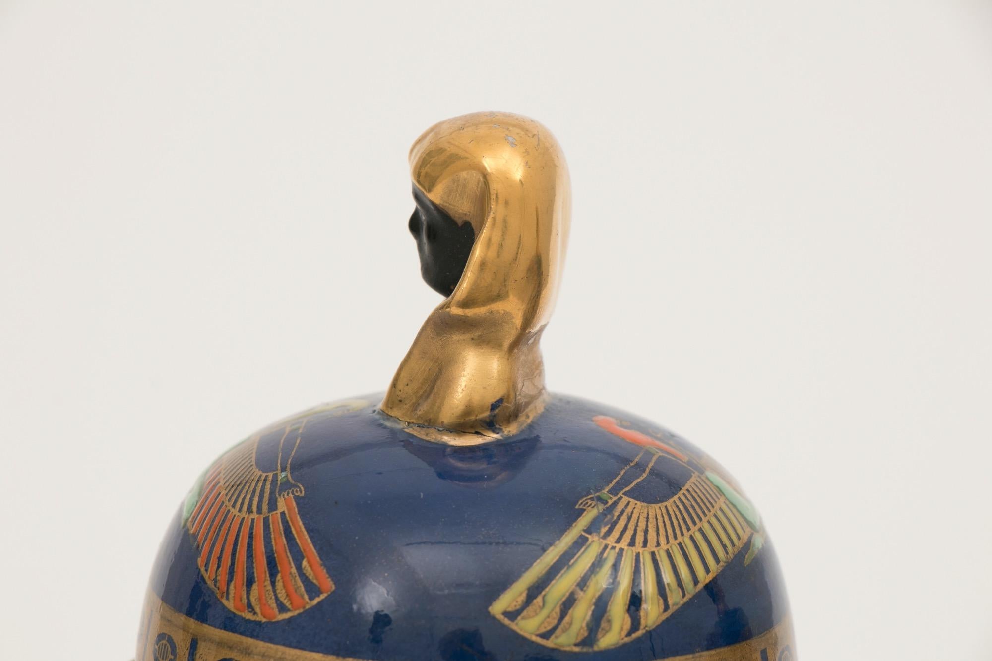 A pair of Art Deco Carltonware temple jars designed by Enoch Boulton with a Death Mask Lid. Tutankhamun design 22ct gilt and enamel decoration.
Measures: H 27cm, W 13cm, D 13cm
British, circa 1925

Carlton Ware created this design to celebrate